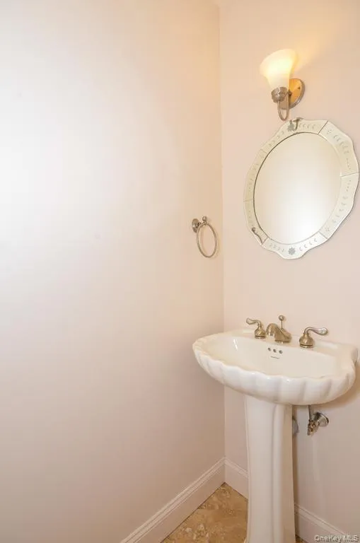Bathroom featuring light tile patterned floors and baseboards Bathroom featuring light tile patterned floors and baseboards