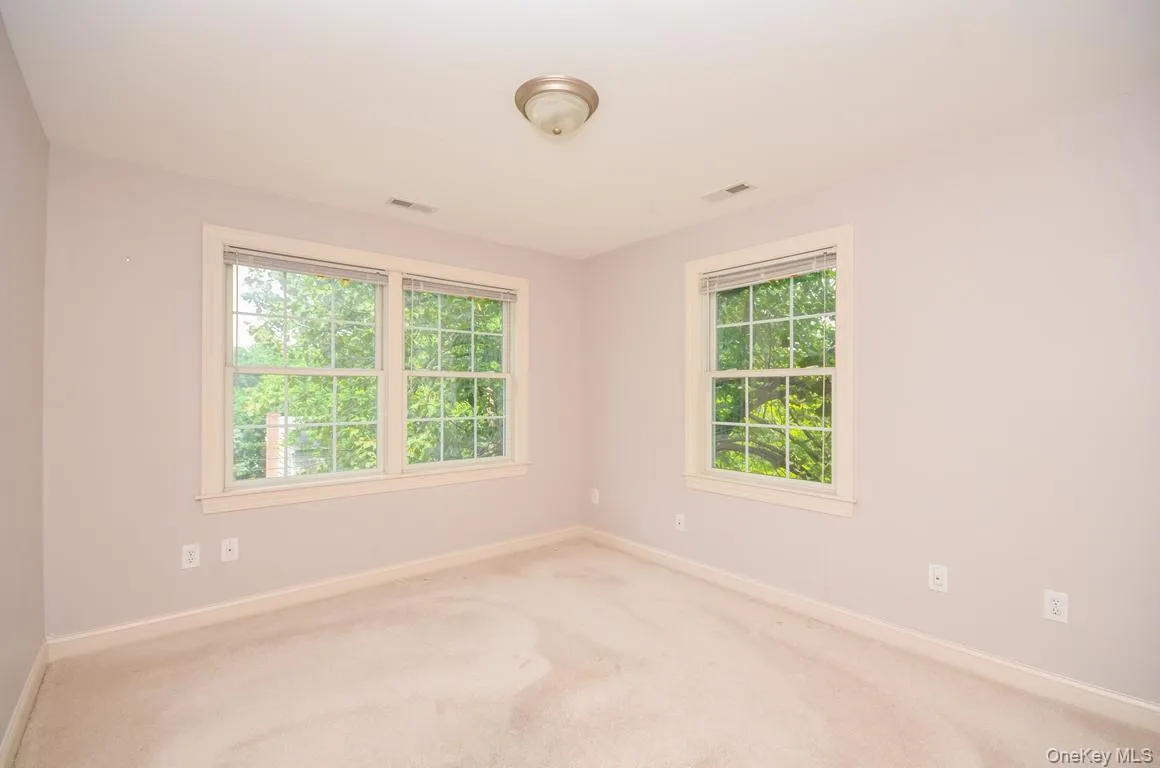 Carpeted spare room featuring baseboards Carpeted spare room featuring baseboards