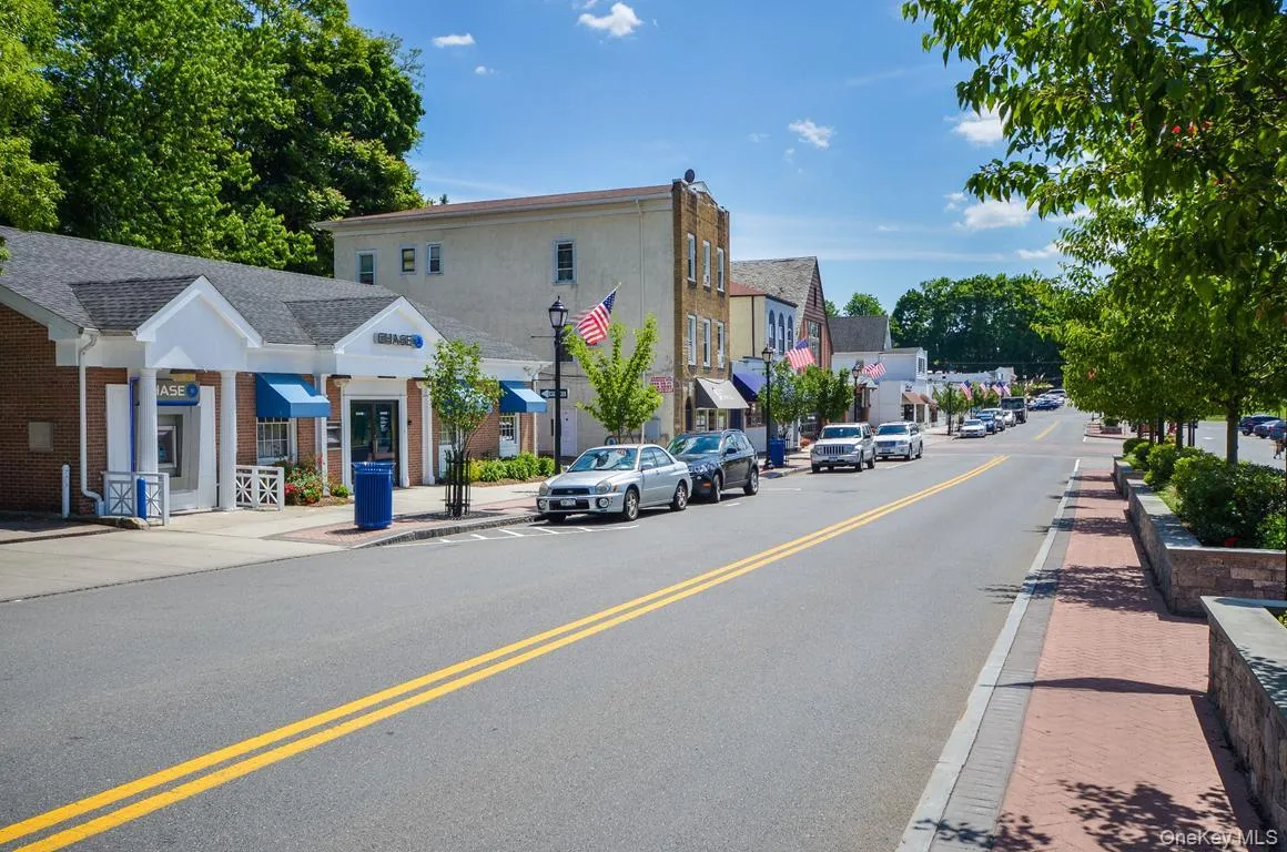 View of asphalt road featuring sidewalks, curbs, street lights, and a residential view View of asphalt road featuring sidewalks, curbs, street lights, and a residential view