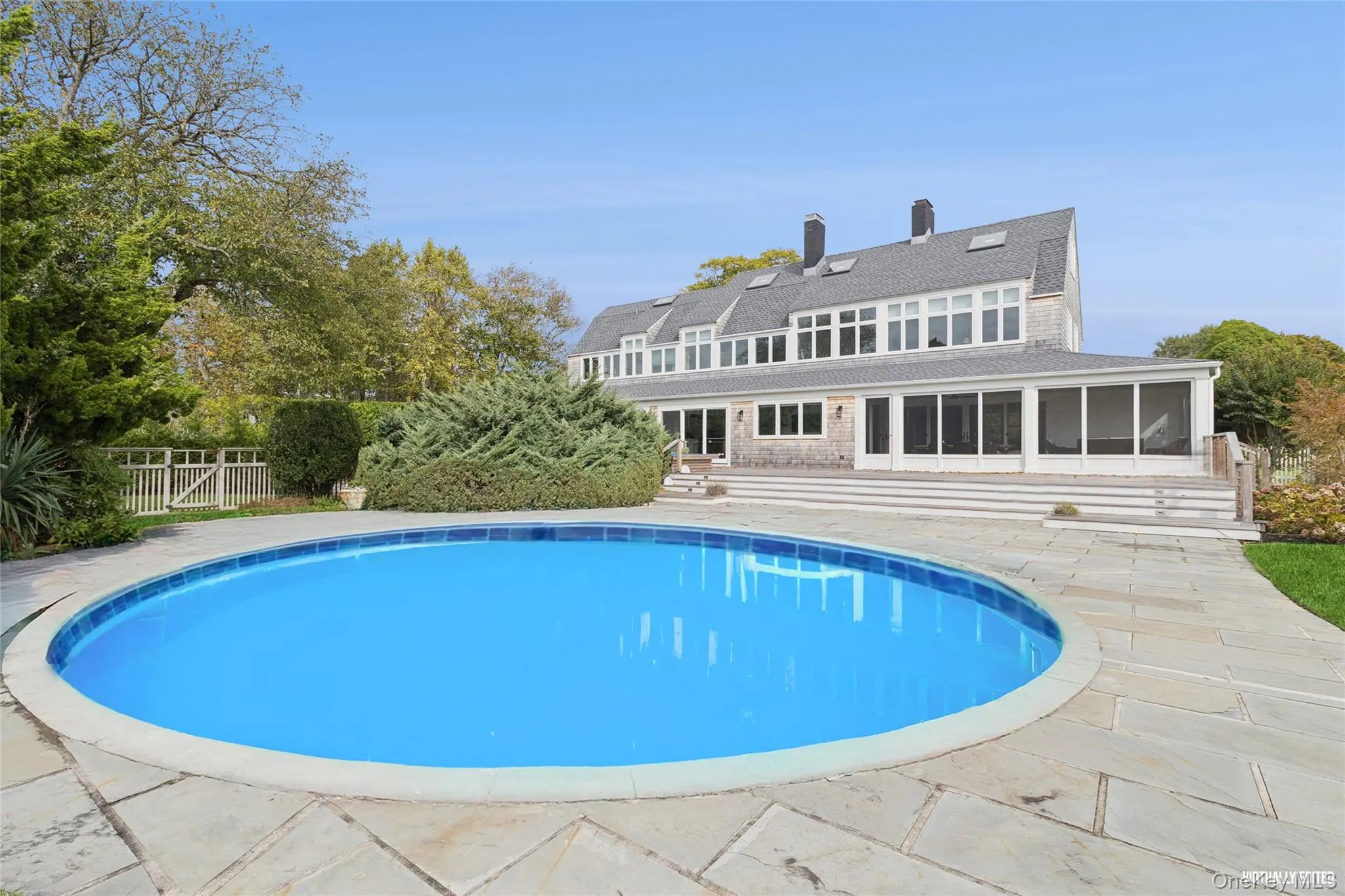 View of pool featuring a sunroom and a patio area View of pool featuring a sunroom and a patio area