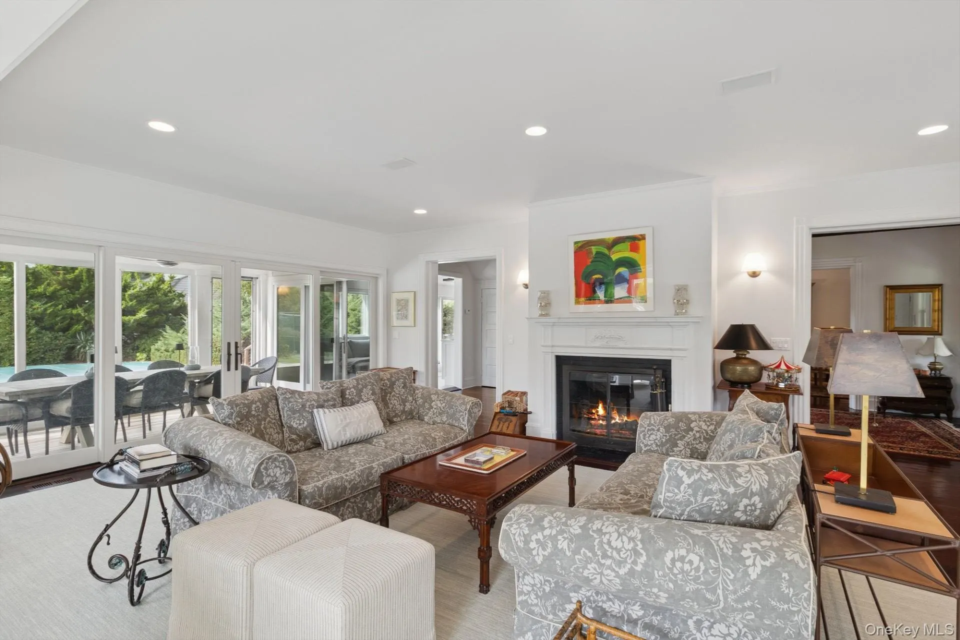 Living area with recessed lighting, a glass covered fireplace, and wood finished floors Living area with recessed lighting, a glass covered fireplace, and wood finished floors