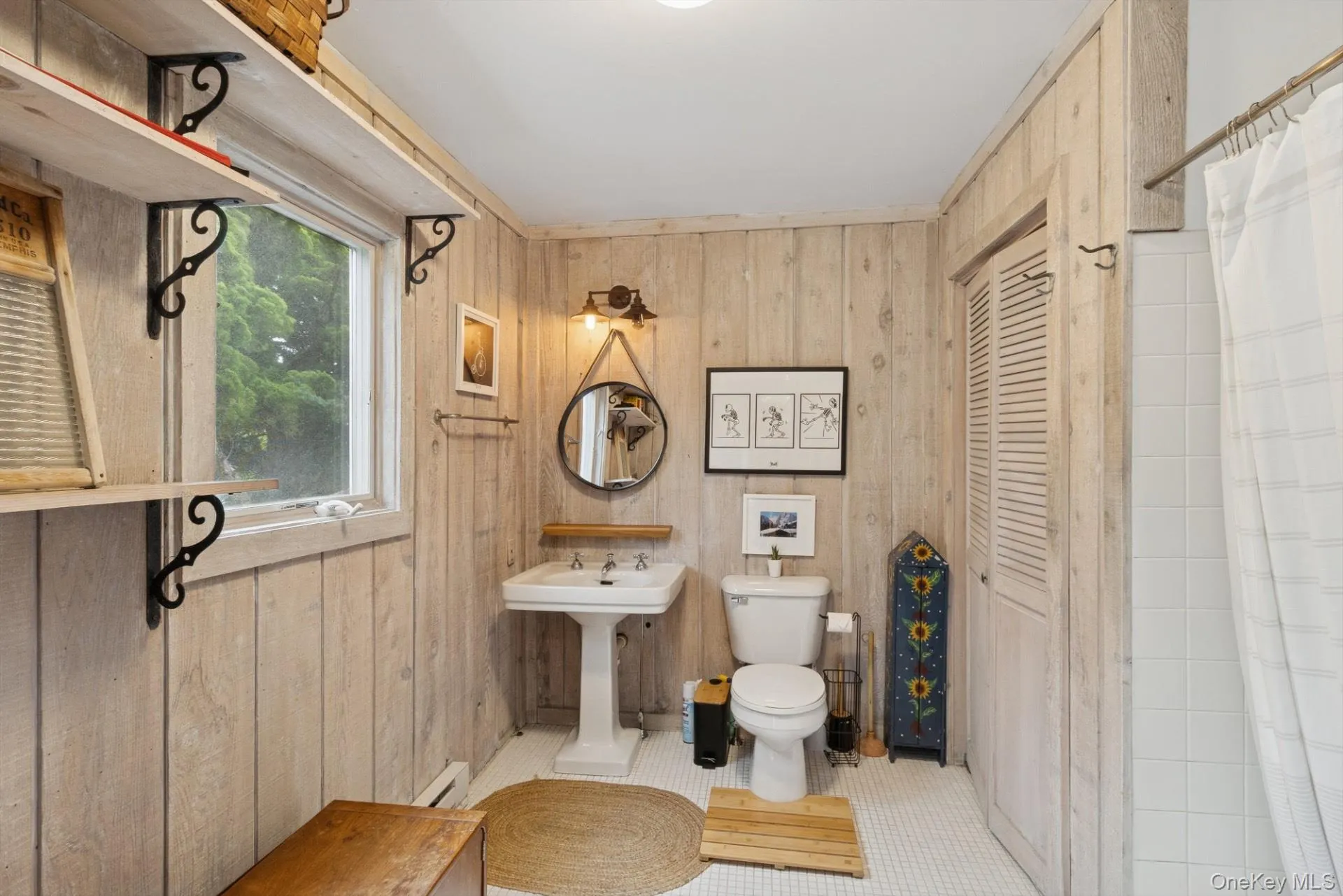 Bathroom featuring tile patterned floors, wooden walls, curtained shower, and baseboard heating Bathroom featuring tile patterned floors, wooden walls, curtained shower, and baseboard heating