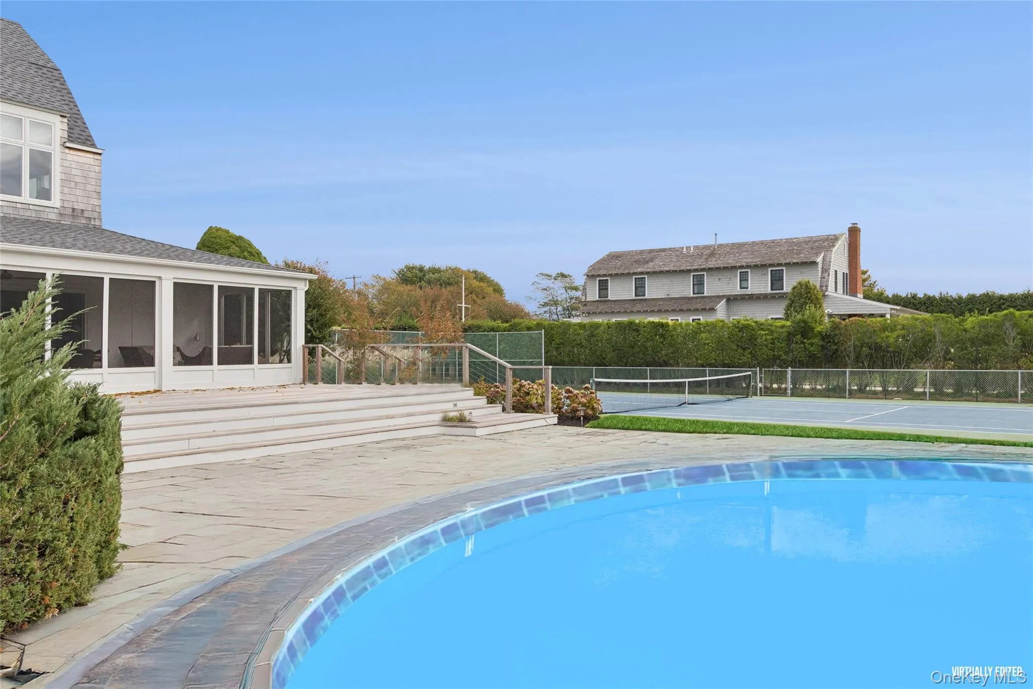 View of swimming pool featuring a tennis court, a patio area, and a sunroom View of swimming pool featuring a tennis court, a patio area, and a sunroom
