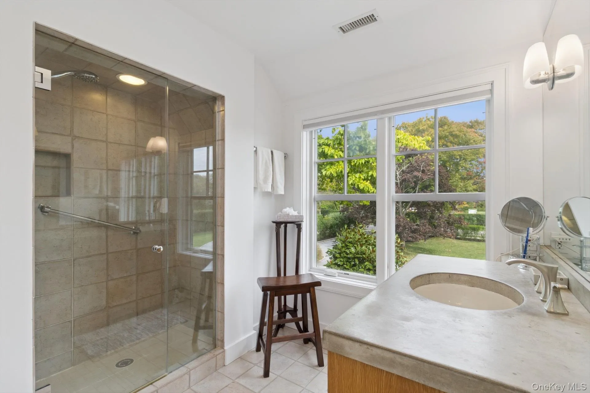 Full bathroom featuring vanity, a stall shower, and light tile patterned floors Full bathroom featuring vanity, a stall shower, and light tile patterned floors