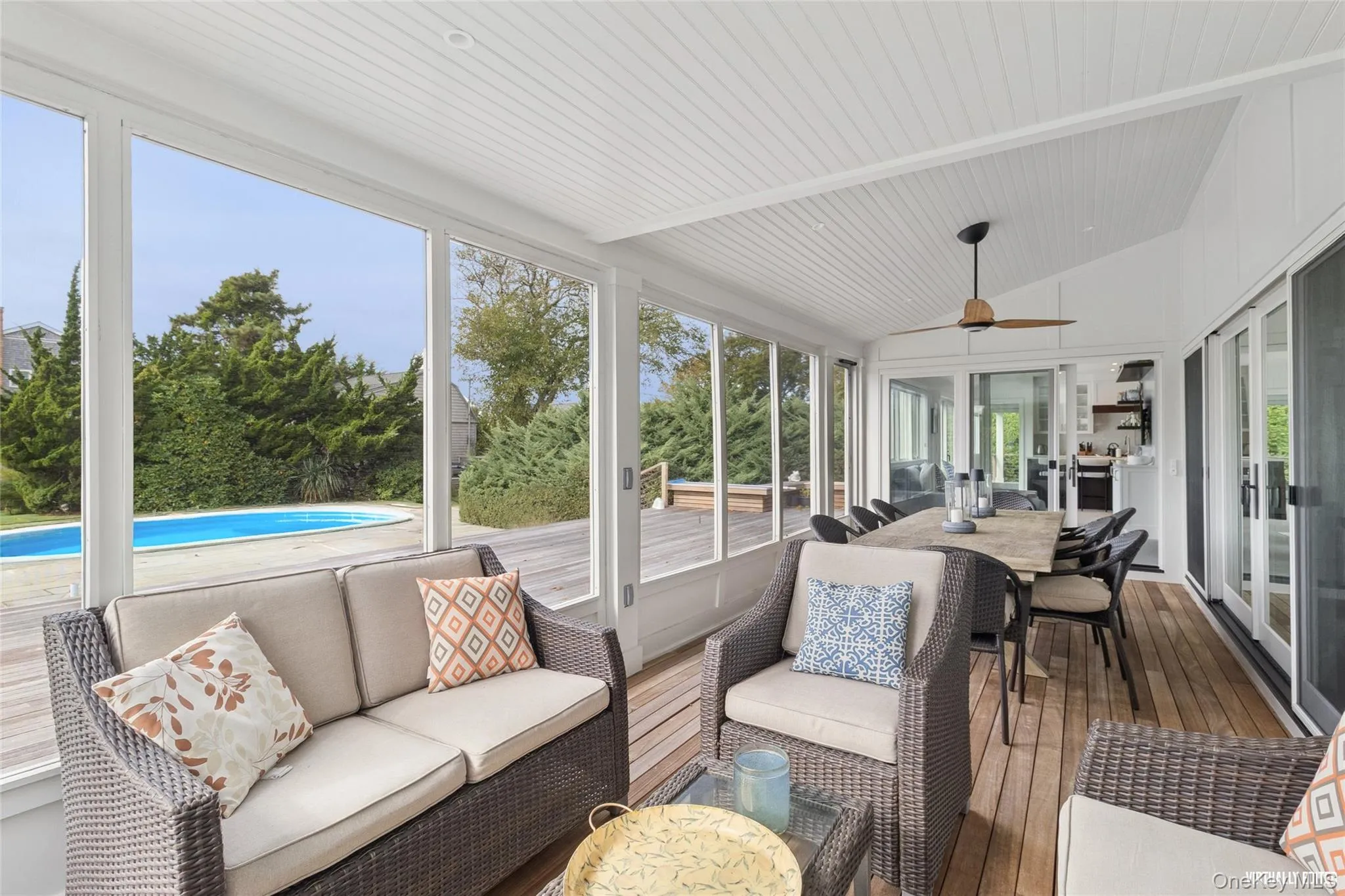 Sunroom / solarium with outdoor dining area, outdoor lounge area, ceiling fan, lofted ceiling, and a wooden deck Sunroom / solarium with outdoor dining area, outdoor lounge area, ceiling fan, lofted ceiling, and a wooden deck