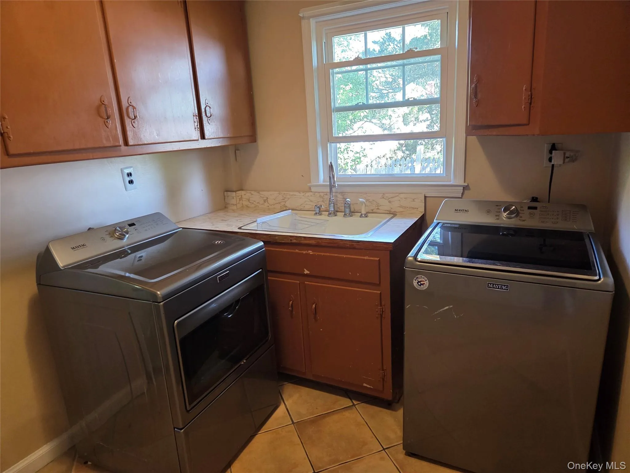Laundry room featuring light tile patterned floors, cabinet space, and independent washer and dryer Laundry room featuring light tile patterned floors, cabinet space, and independent washer and dryer