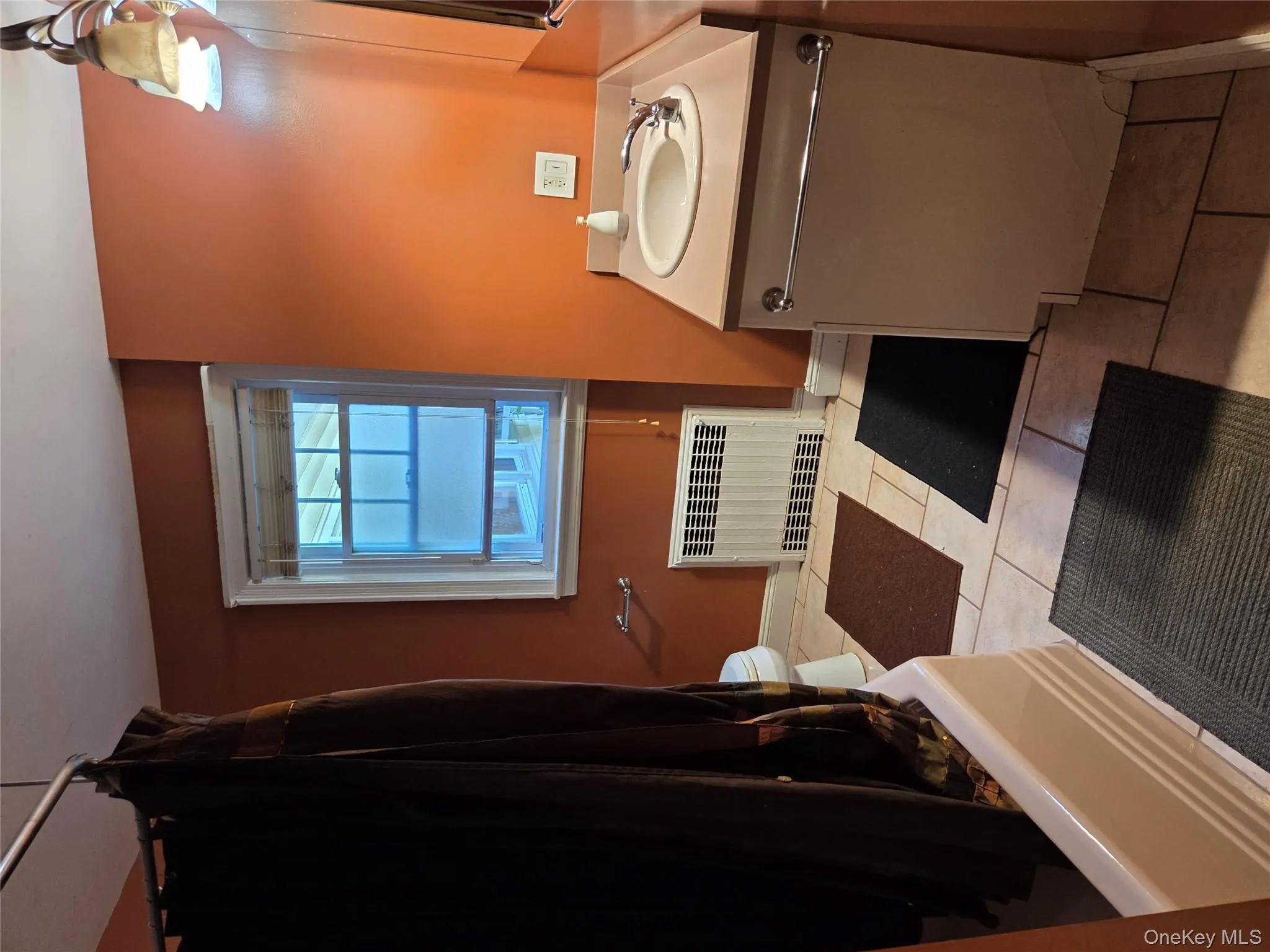 Bathroom featuring radiator, vanity, light tile patterned floors, and shower / tub combo Bathroom featuring radiator, vanity, light tile patterned floors, and shower / tub combo