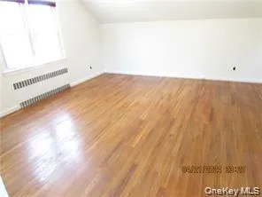 Bonus room with wood finished floors, lofted ceiling, and a baseboard radiator Bonus room with wood finished floors, lofted ceiling, and a baseboard radiator