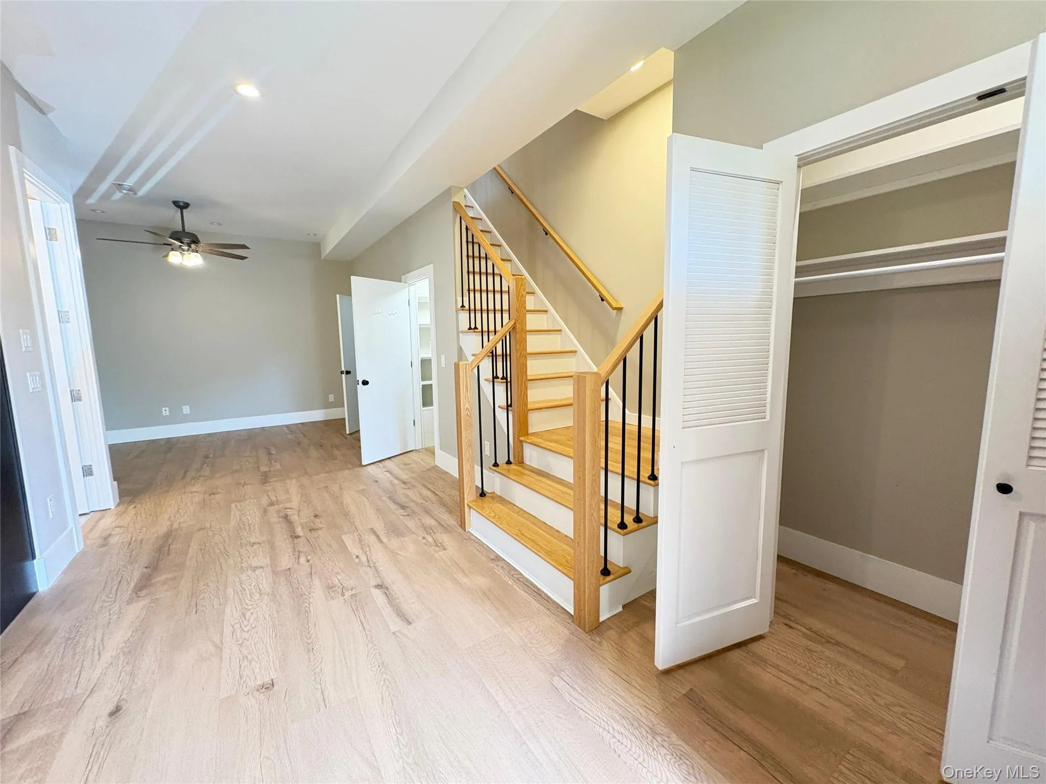 Stairway with wood finished floors, a ceiling fan, and recessed lighting Stairway with wood finished floors, a ceiling fan, and recessed lighting