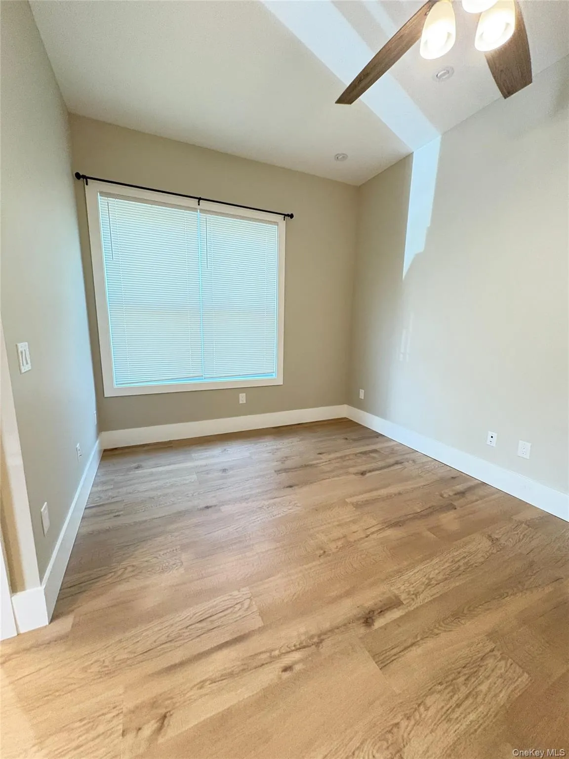 Empty room with light wood-style floors and ceiling fan Empty room with light wood-style floors and ceiling fan