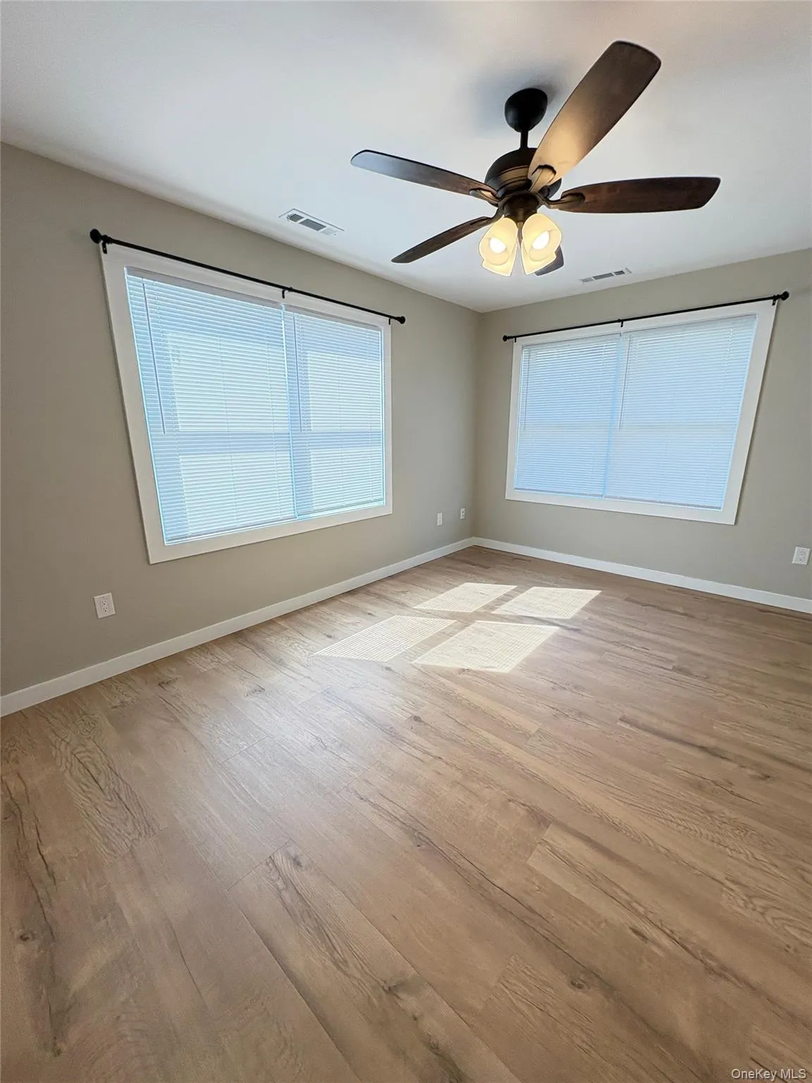 Unfurnished room featuring light wood-style floors and a ceiling fan Unfurnished room featuring light wood-style floors and a ceiling fan