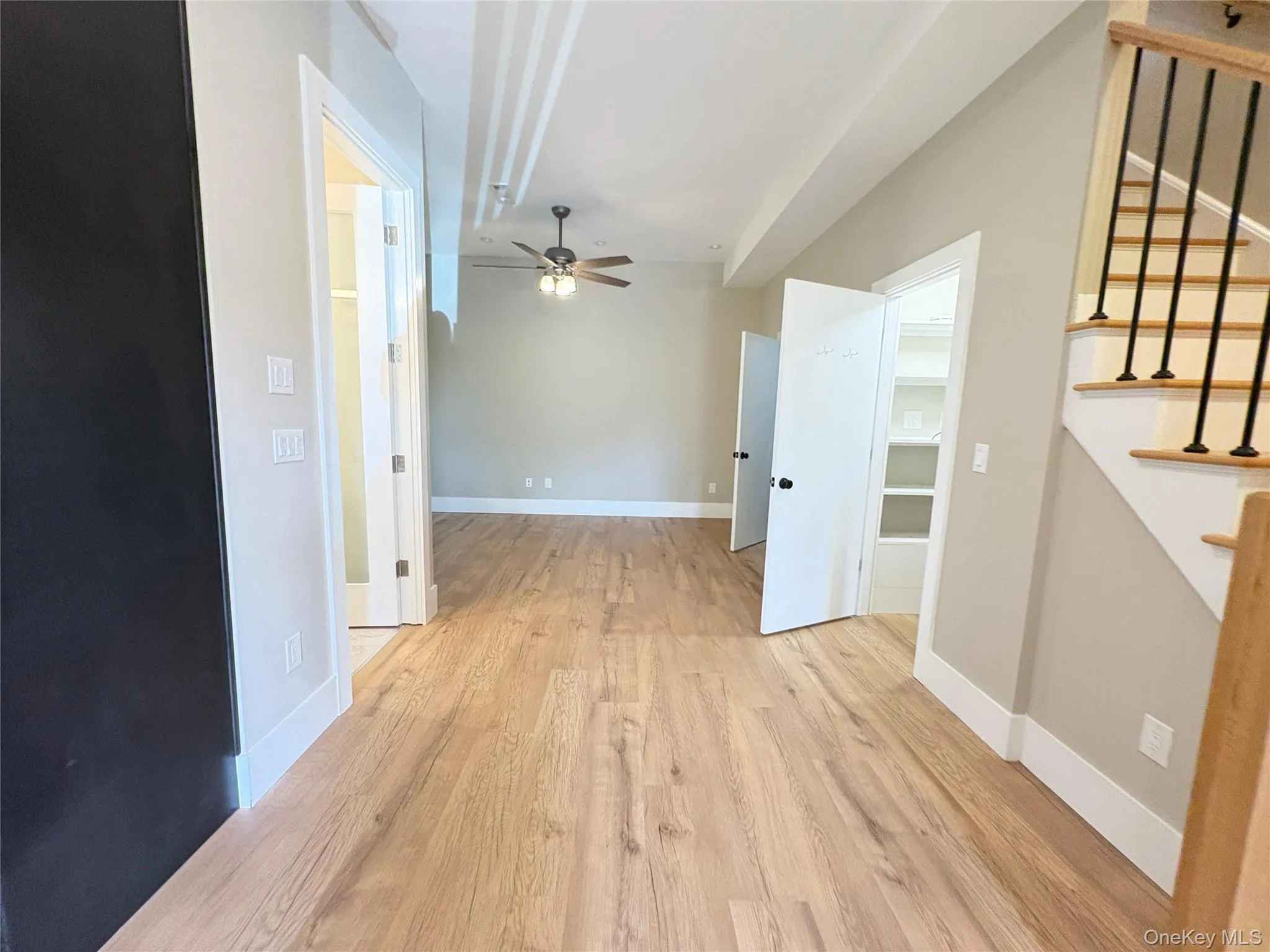 Unfurnished living room featuring light wood-style floors, stairway, and ceiling fan Unfurnished living room featuring light wood-style floors, stairway, and ceiling fan