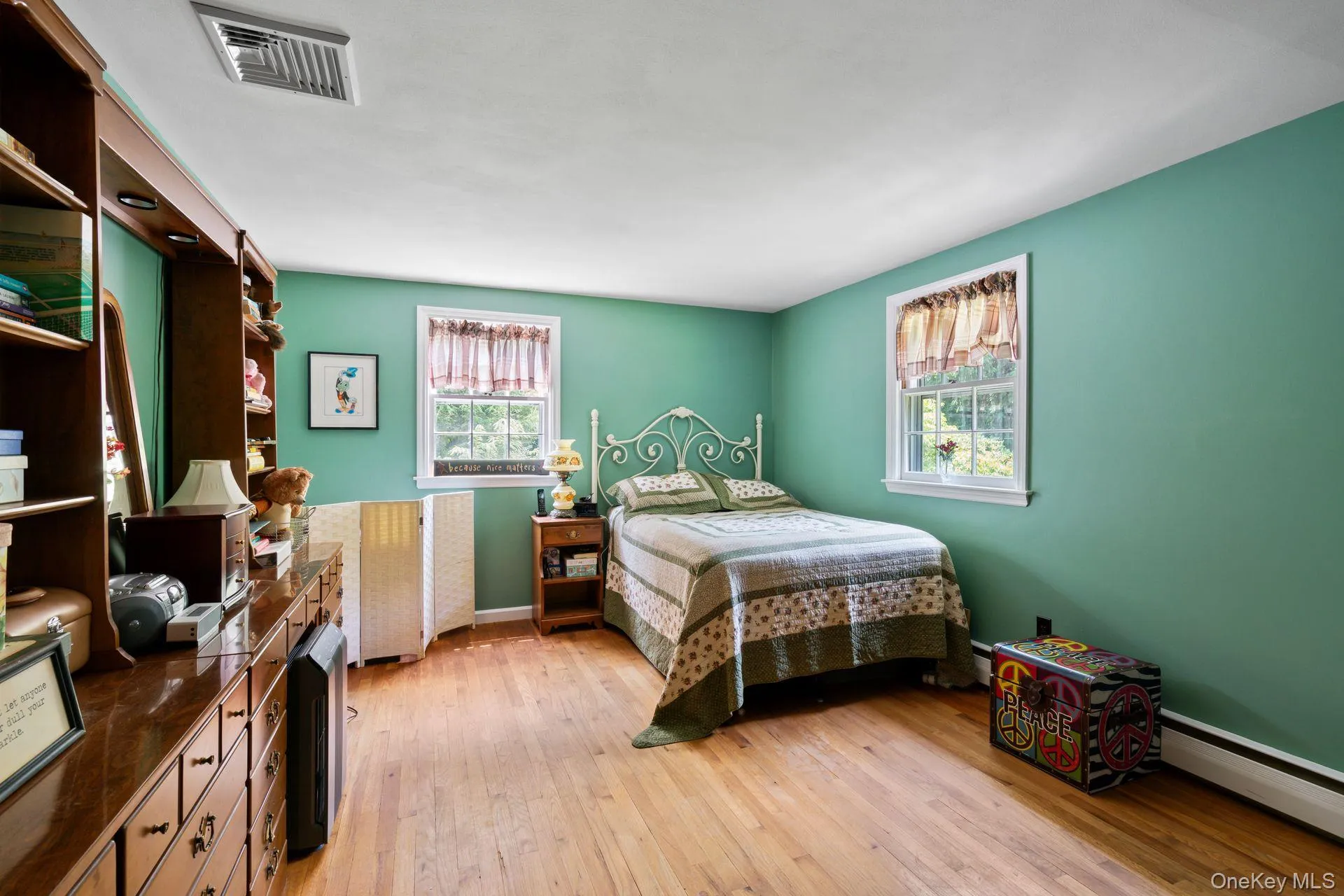 Bedroom with light wood-style floors and a baseboard radiator Bedroom with light wood-style floors and a baseboard radiator