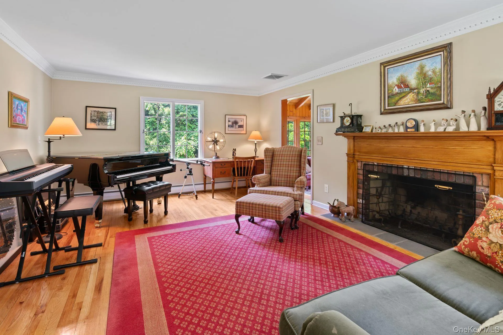 Living area with ornamental molding, light wood-type flooring, a brick fireplace, and a baseboard radiator Living area with ornamental molding, light wood-type flooring, a brick fireplace, and a baseboard radiator