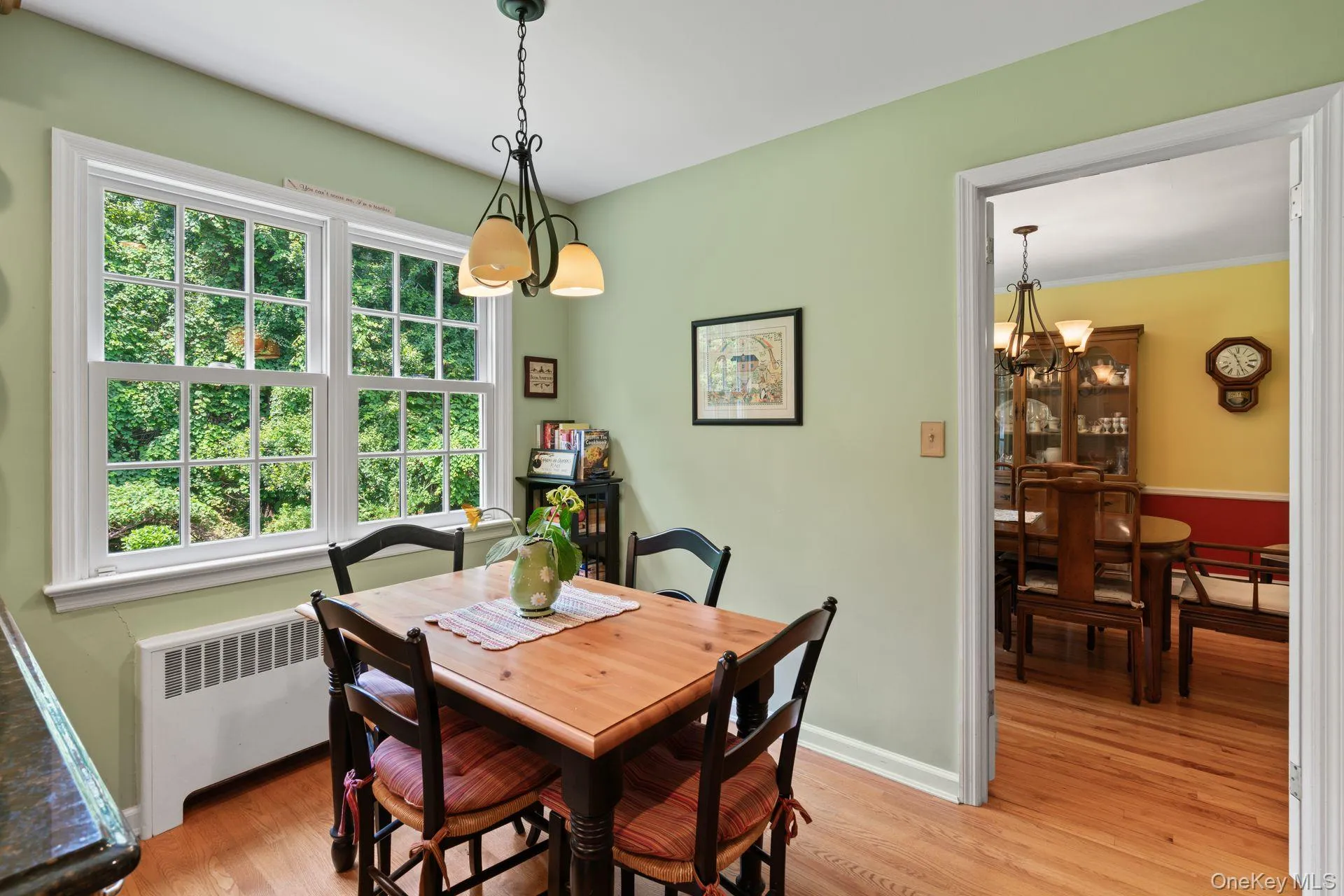 Dining space with a chandelier, radiator, light wood finished floors, and a baseboard radiator Dining space with a chandelier, radiator, light wood finished floors, and a baseboard radiator