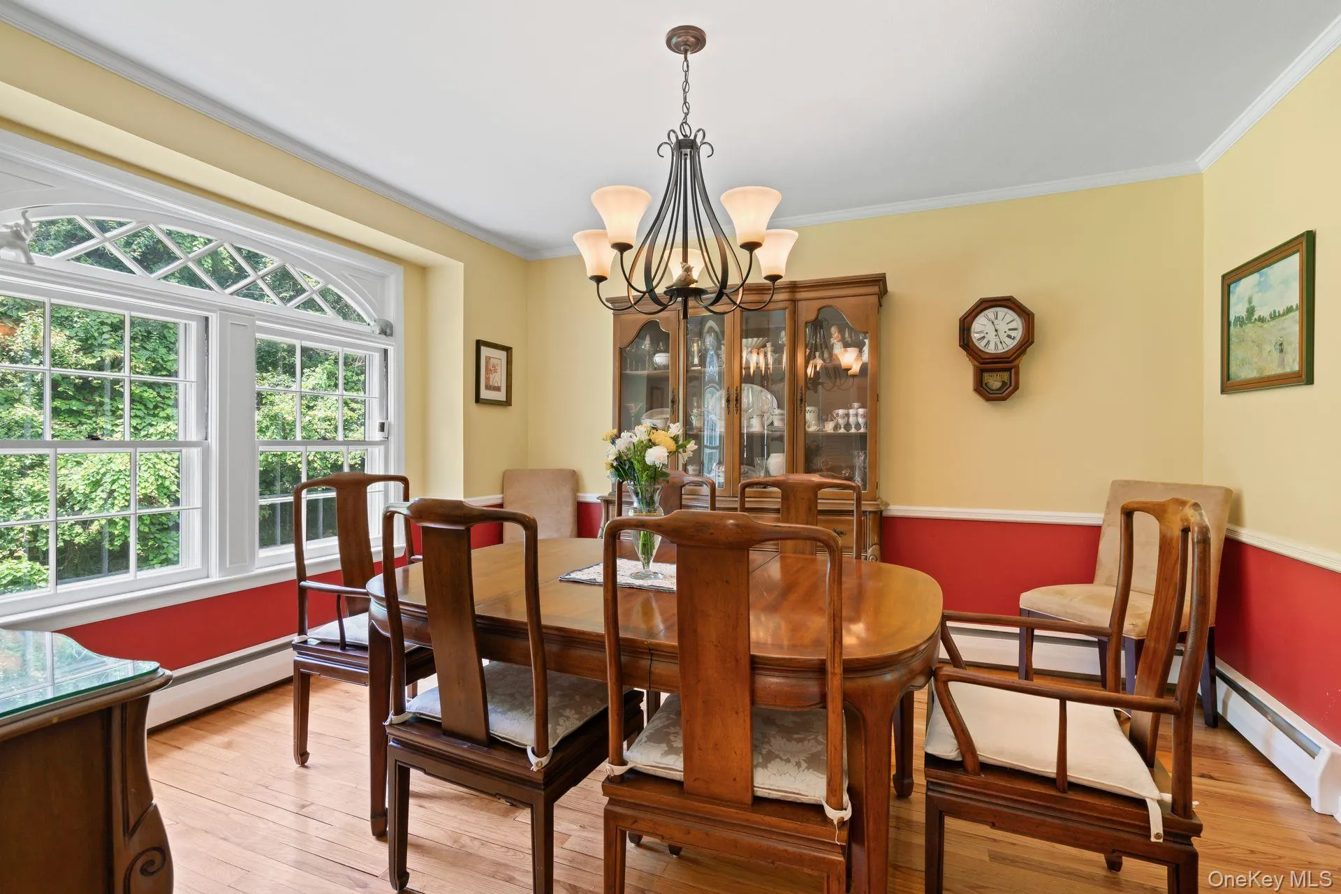 Dining space with crown molding, a chandelier, light wood-style floors, and a baseboard radiator Dining space with crown molding, a chandelier, light wood-style floors, and a baseboard radiator