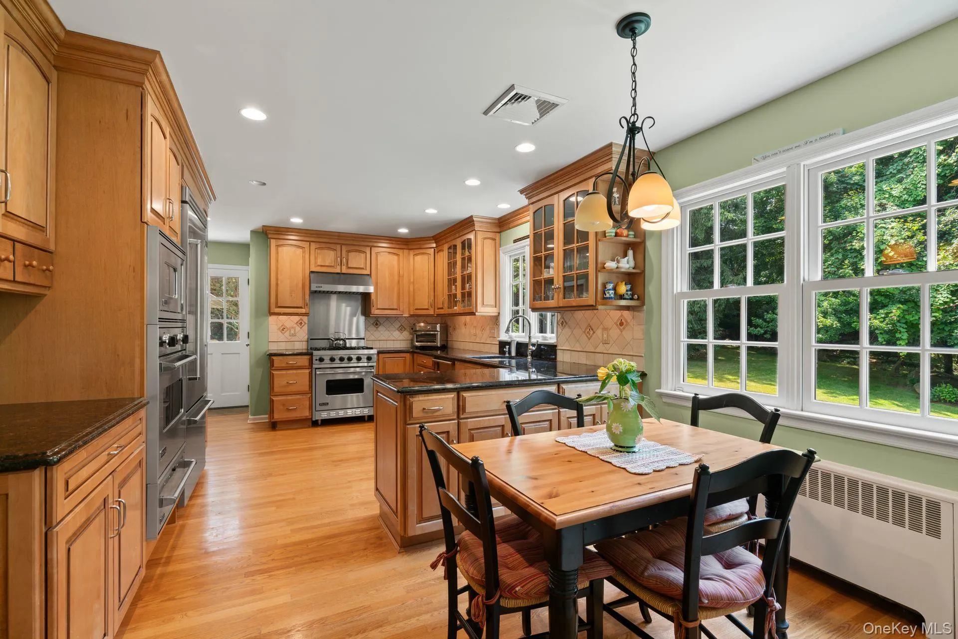 Dining space featuring light wood-style flooring, radiator, and recessed lighting Dining space featuring light wood-style flooring, radiator, and recessed lighting
