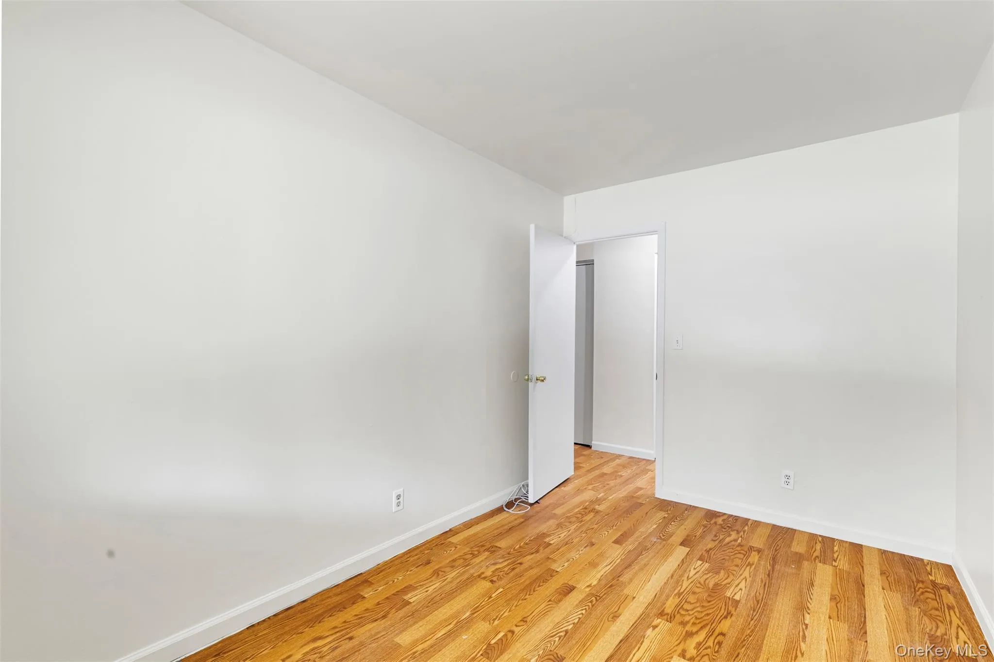 Bedroom featuring wood finished floors and baseboards Bedroom featuring wood finished floors and baseboards