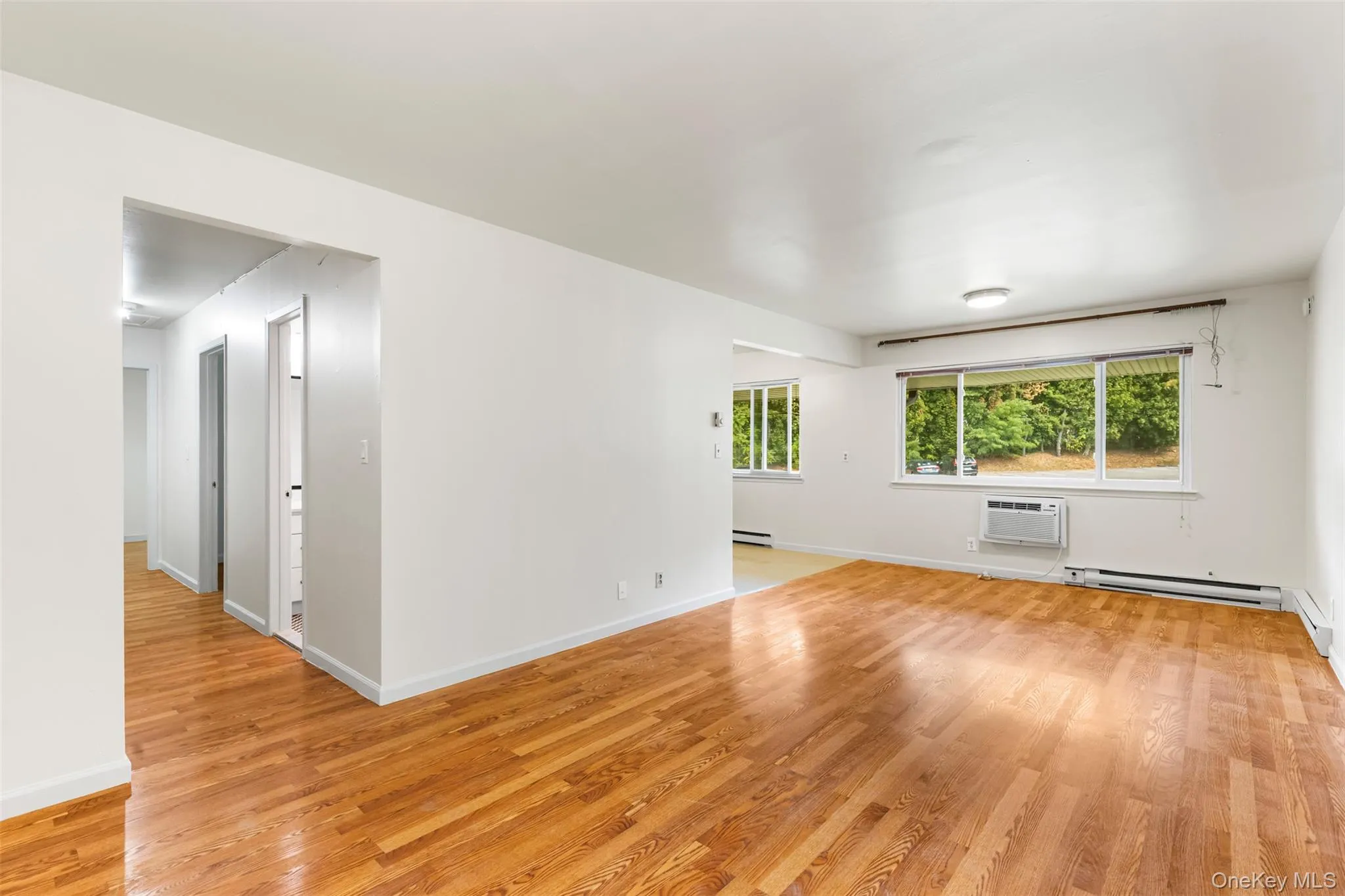 Spare room featuring light wood finished floors and a baseboard heating unit Spare room featuring light wood finished floors and a baseboard heating unit