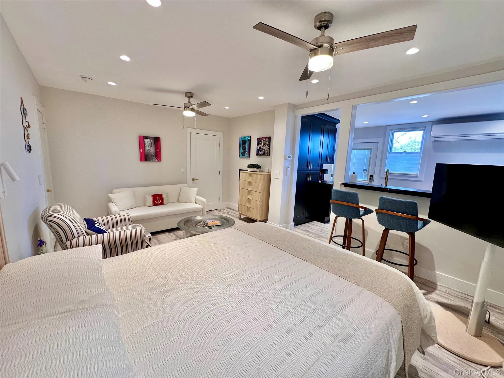 Bedroom with an AC wall unit, recessed lighting, wood finished floors, and a ceiling fan Bedroom with an AC wall unit, recessed lighting, wood finished floors, and a ceiling fan
