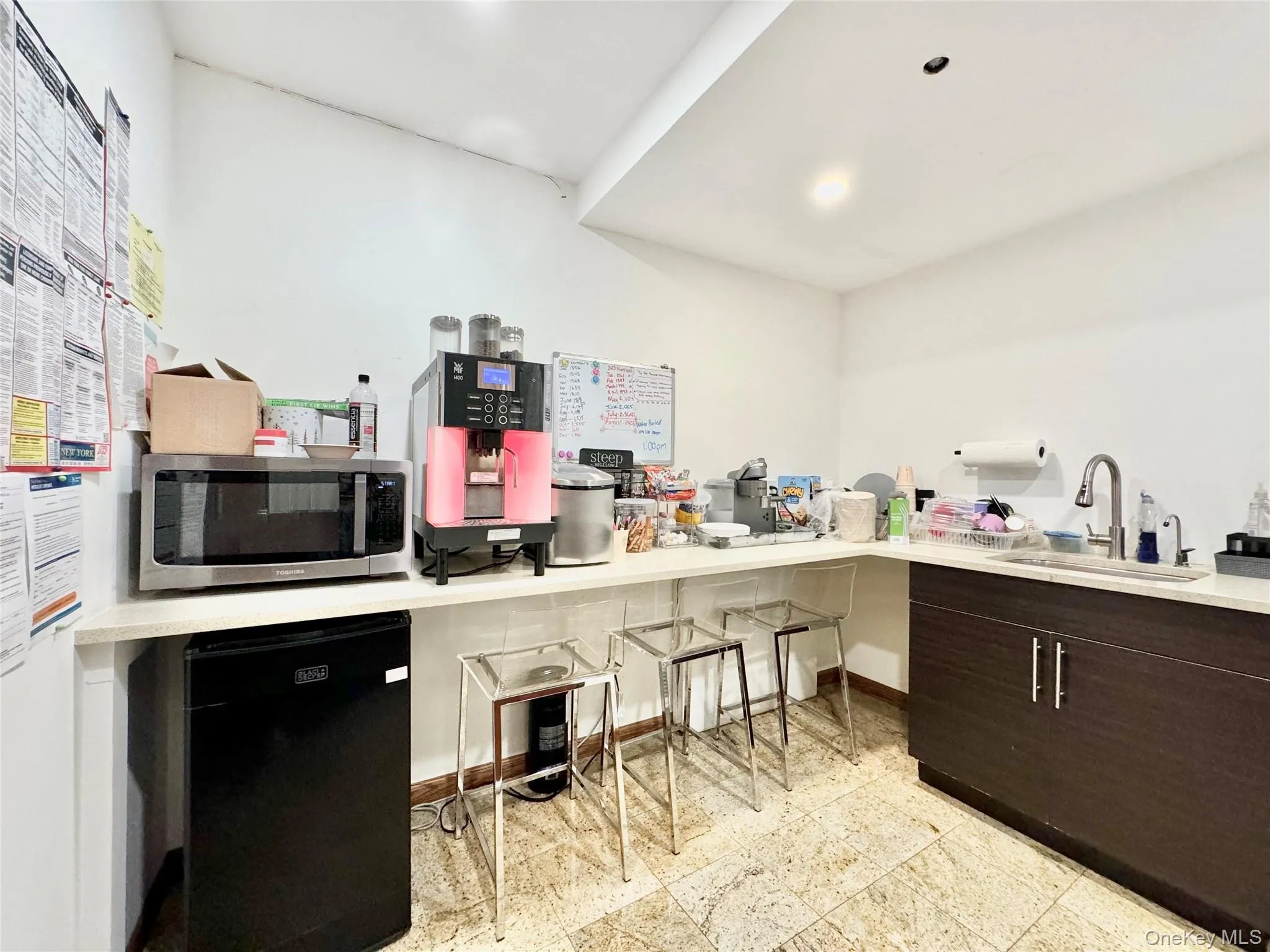 Kitchen featuring black fridge, dark brown cabinets, stainless steel microwave, modern cabinets, and recessed lighting Kitchen featuring black fridge, dark brown cabinets, stainless steel microwave, modern cabinets, and recessed lighting
