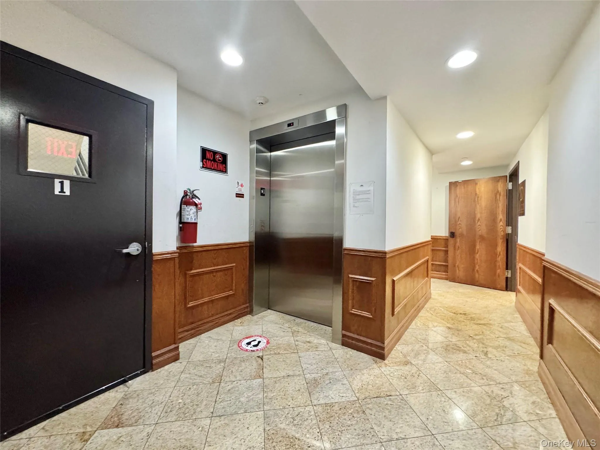 Hall featuring elevator, recessed lighting, and a wainscoted wall Hall featuring elevator, recessed lighting, and a wainscoted wall