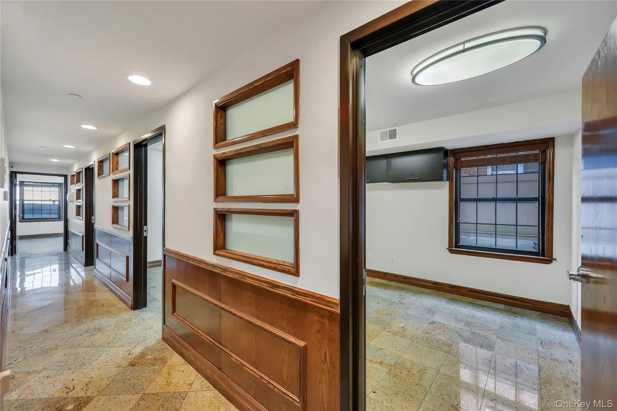Corridor featuring wainscoting and recessed lighting Corridor featuring wainscoting and recessed lighting