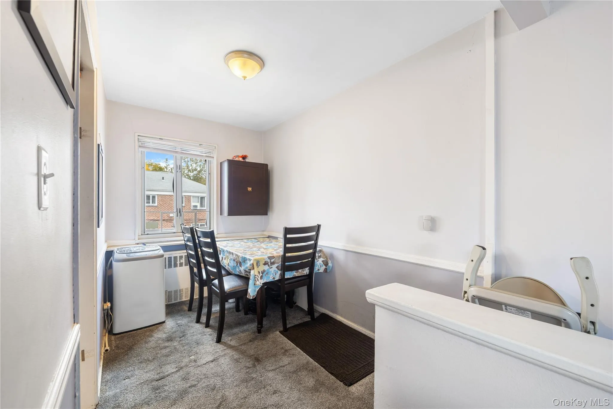 Dining space featuring light colored carpet and radiator heating unit Dining space featuring light colored carpet and radiator heating unit