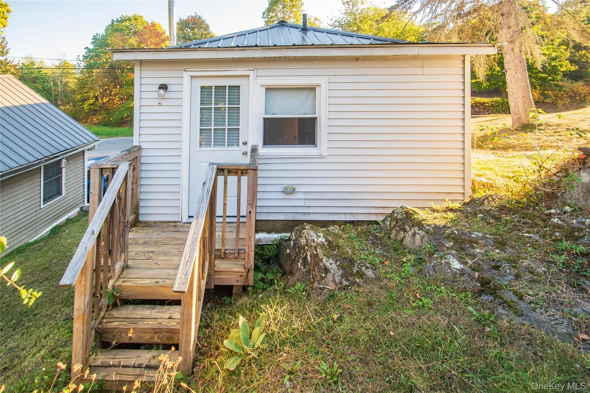Rear entry door into bedroom, with small porch. Rear entry door into bedroom, with small porch.