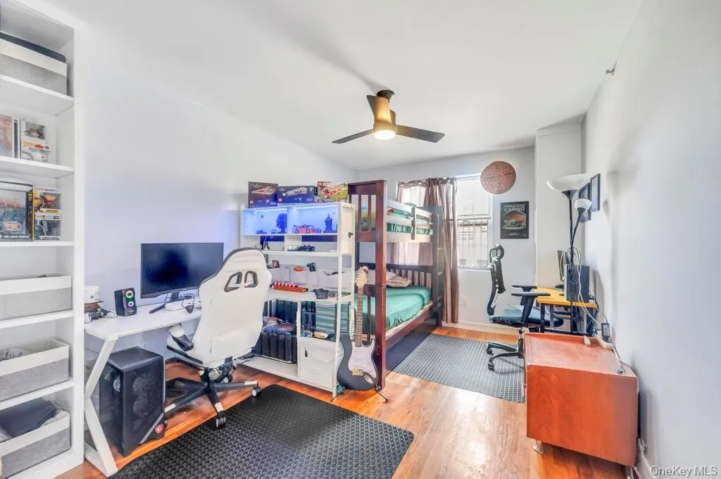 Bedroom featuring a desk, light wood-type flooring, and a ceiling fan Bedroom featuring a desk, light wood-type flooring, and a ceiling fan