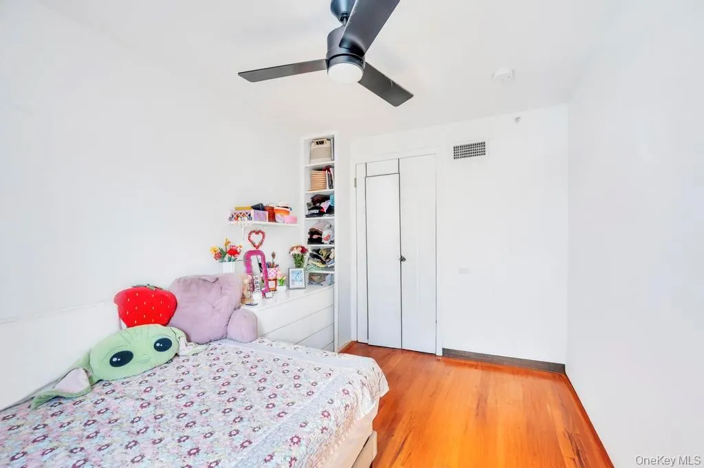 Bedroom with light wood finished floors, a ceiling fan, and a closet Bedroom with light wood finished floors, a ceiling fan, and a closet