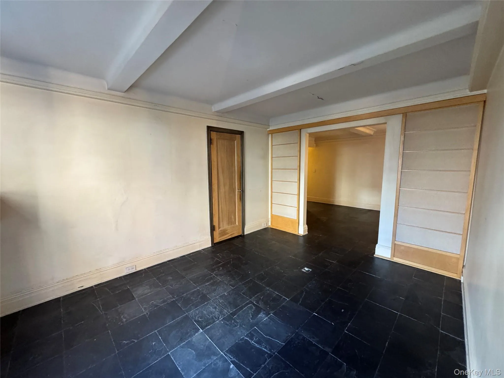 Spare room featuring baseboards and beam ceiling Spare room featuring baseboards and beam ceiling