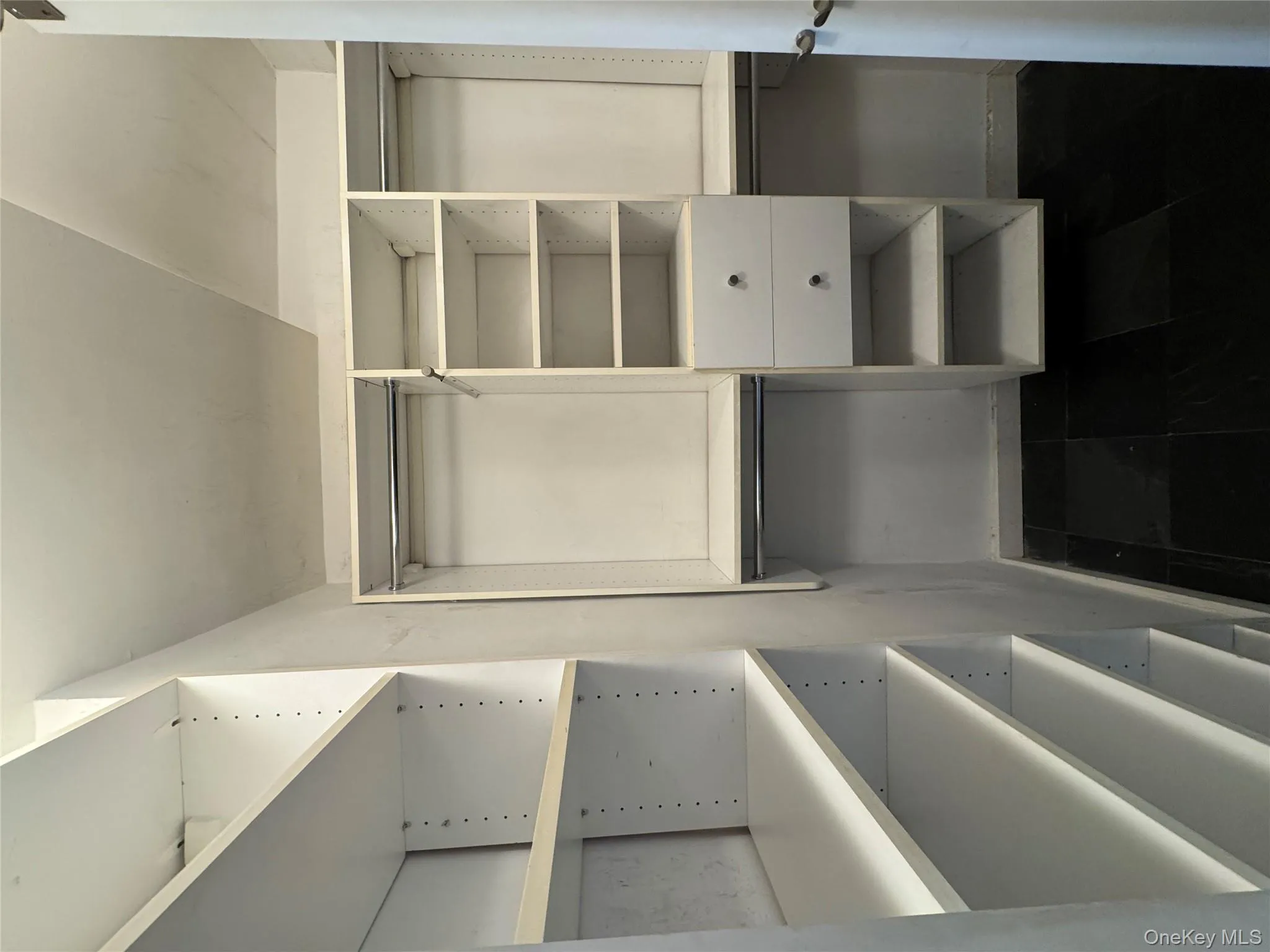 Walk in closet with dark tile patterned floors Walk in closet with dark tile patterned floors