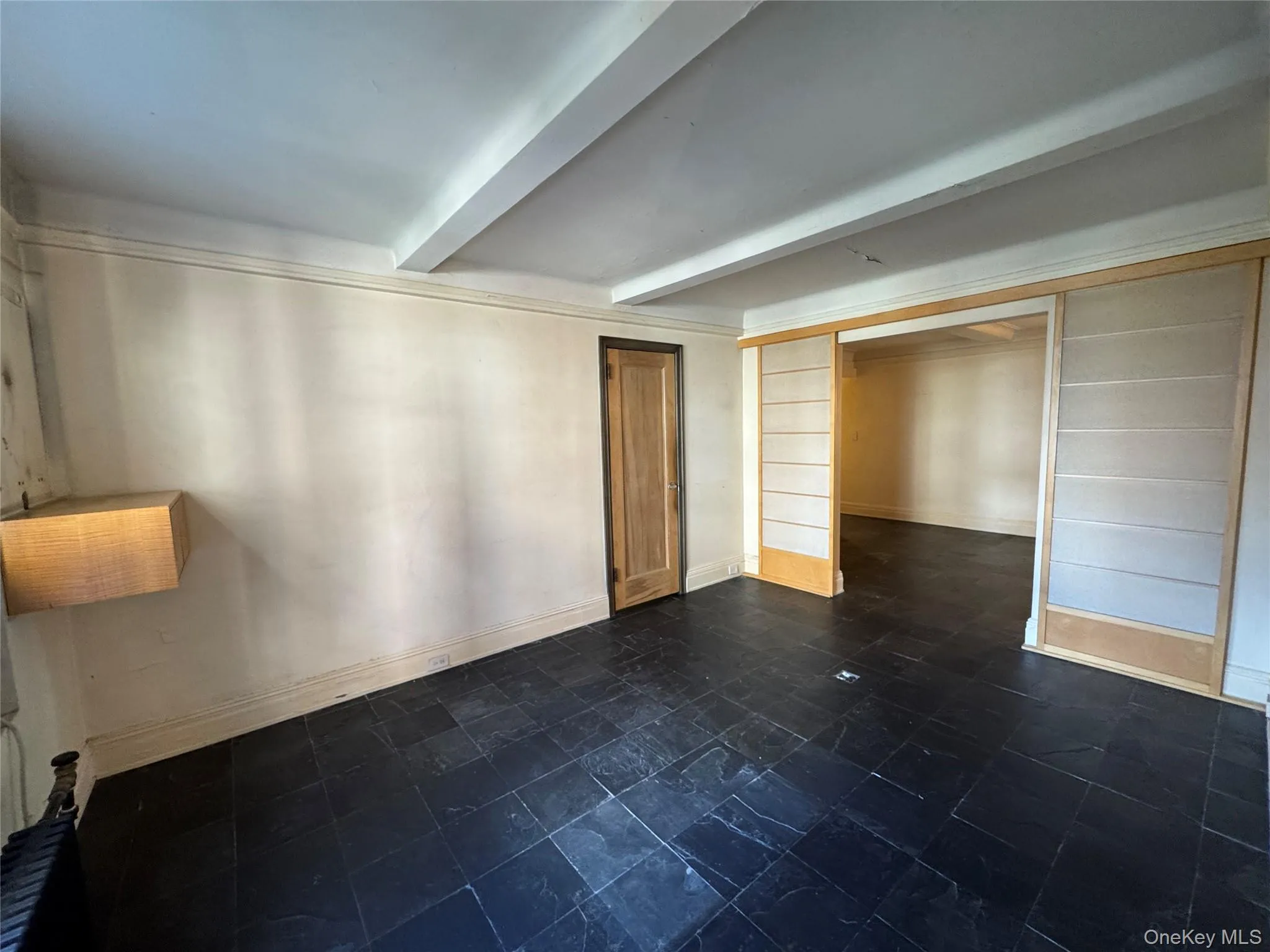Empty room with beam ceiling and baseboards Empty room with beam ceiling and baseboards