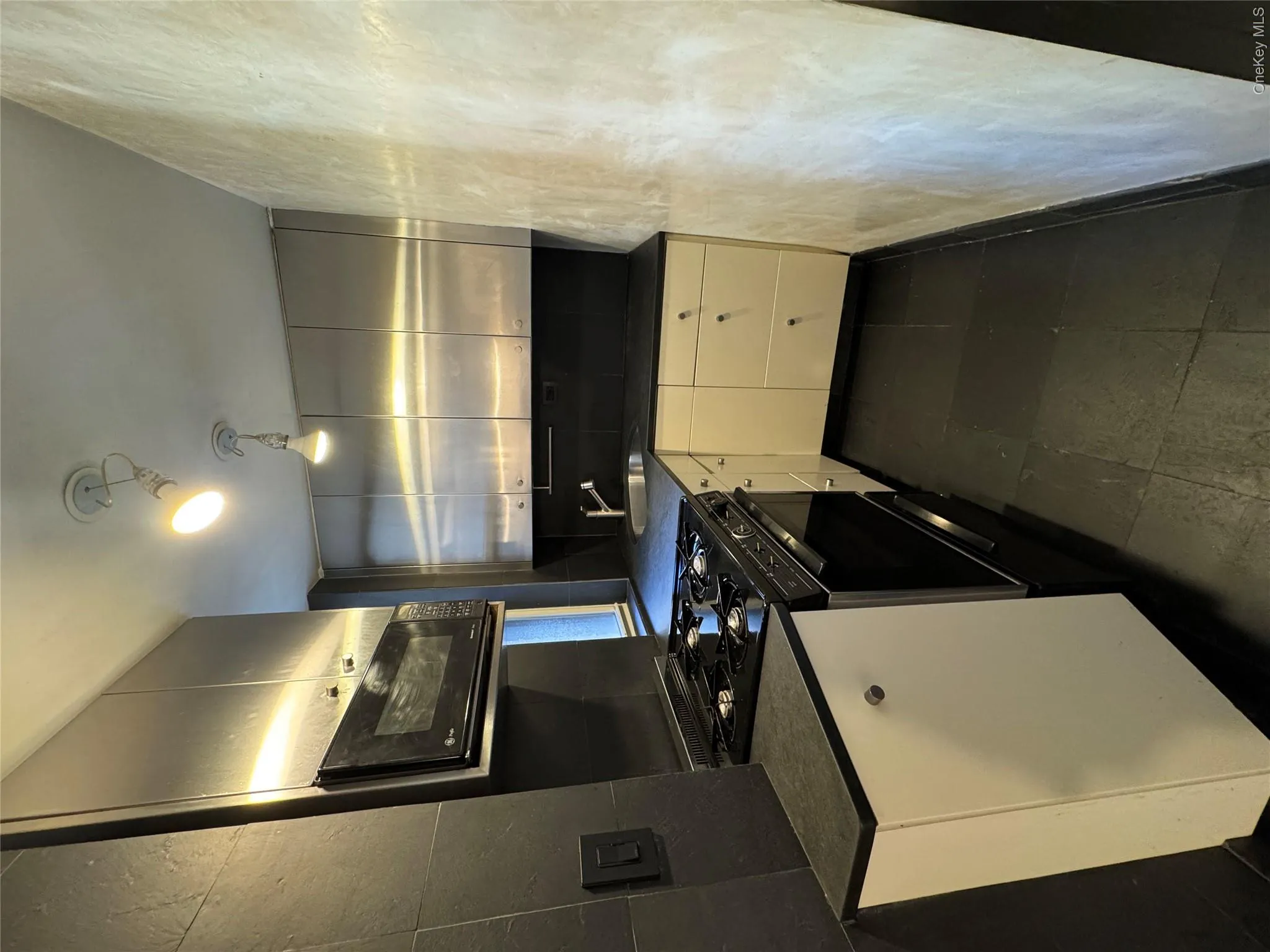 Kitchen featuring dark countertops and black stove Kitchen featuring dark countertops and black stove