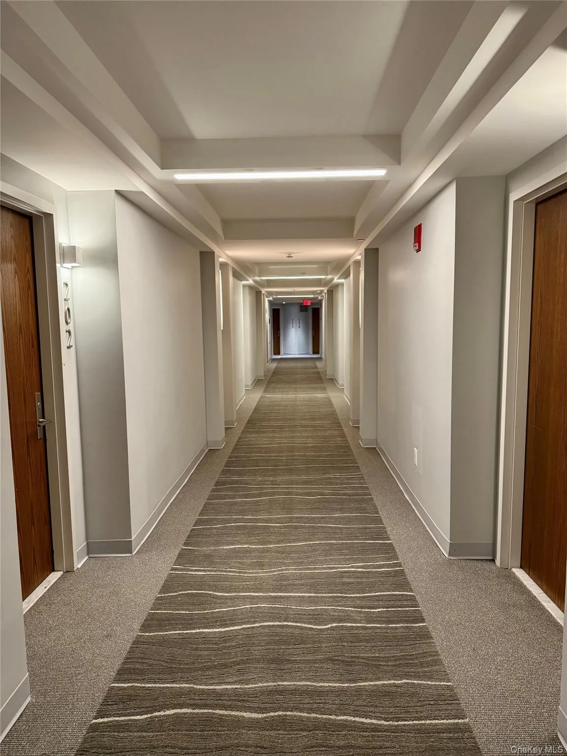Hallway with light carpet Hallway with light carpet