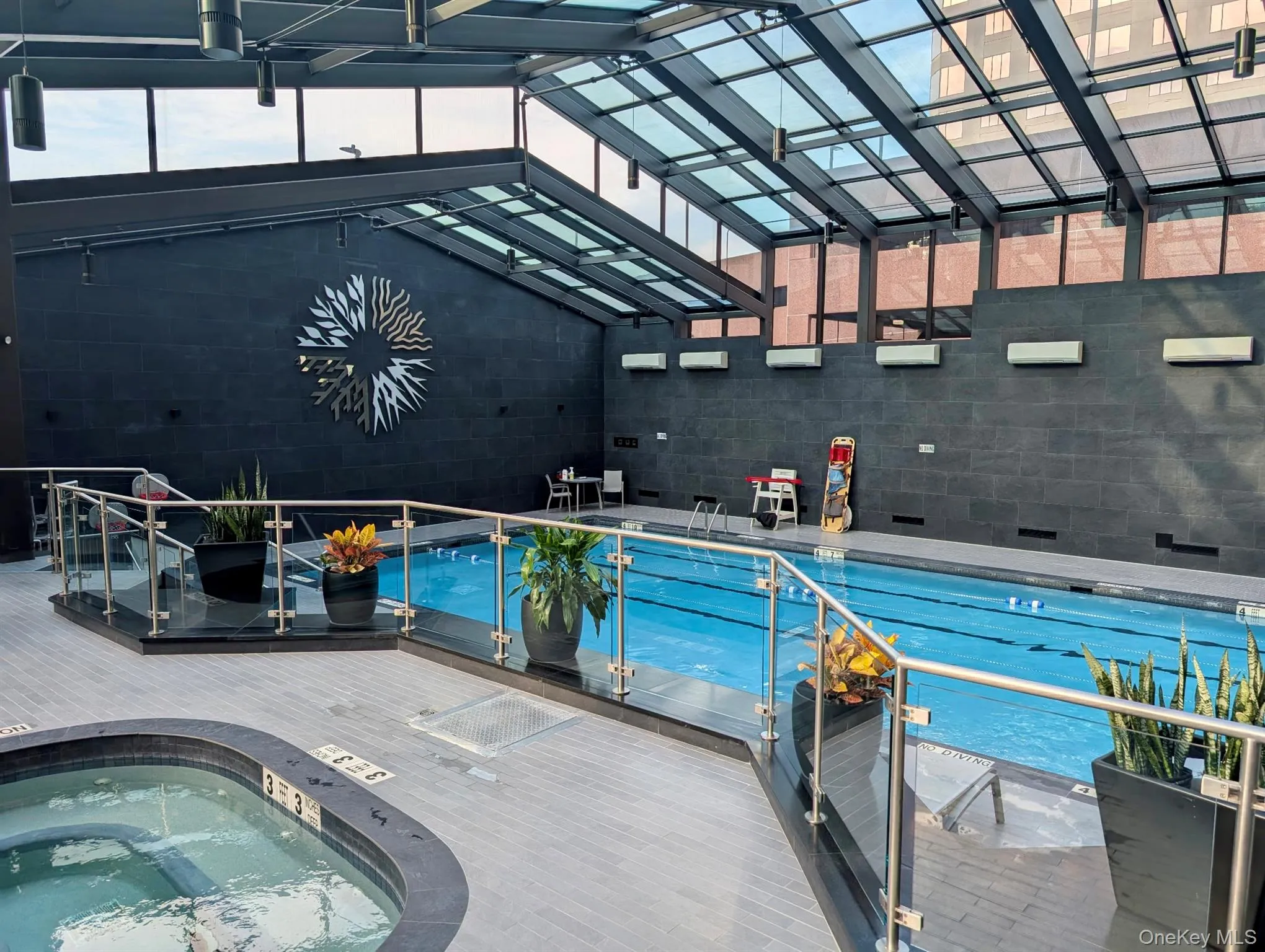 Indoor pool featuring a hot tub and a patio area Indoor pool featuring a hot tub and a patio area