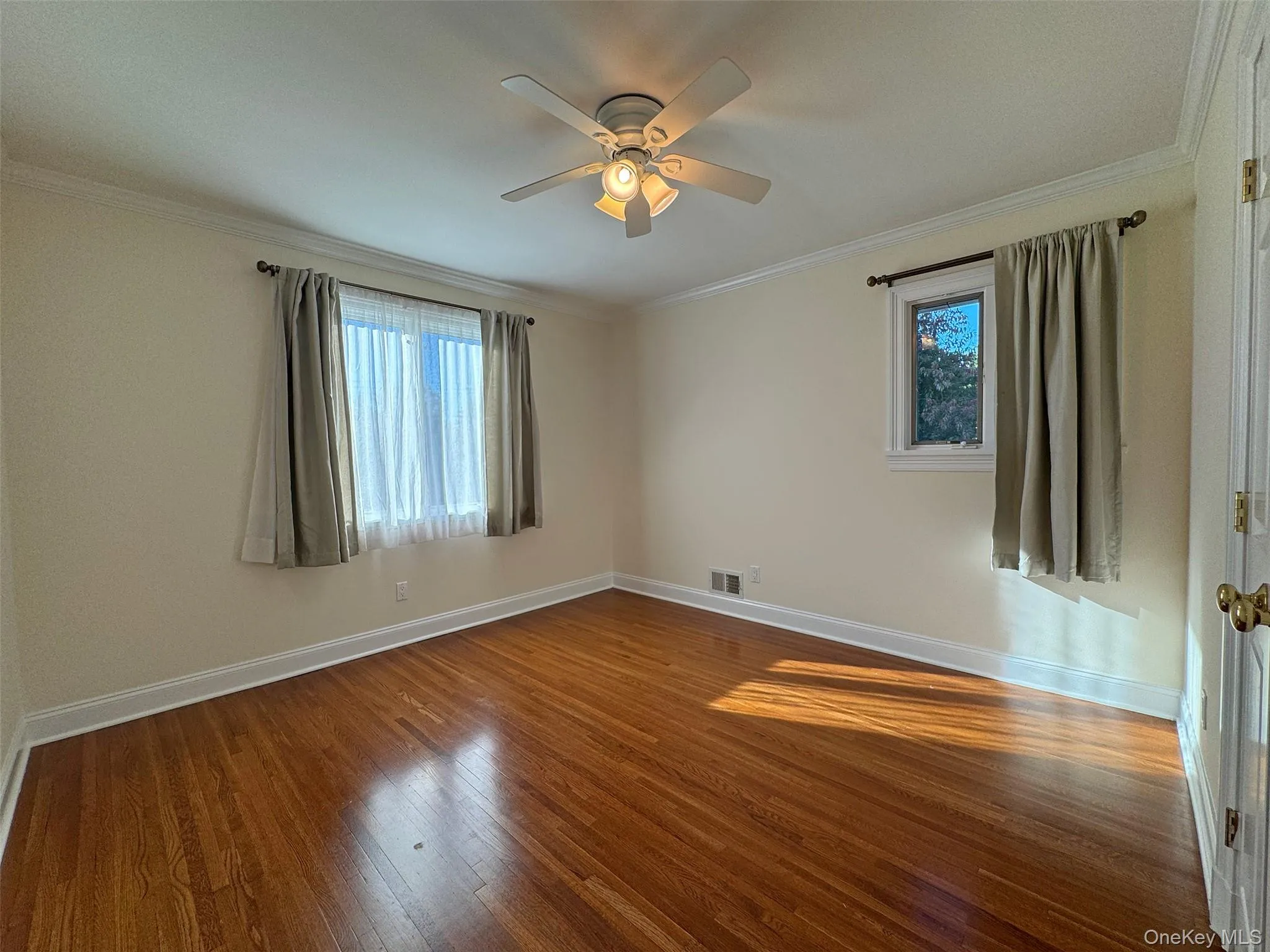 Spare room featuring ornamental molding, dark wood finished floors, and ceiling fan Spare room featuring ornamental molding, dark wood finished floors, and ceiling fan