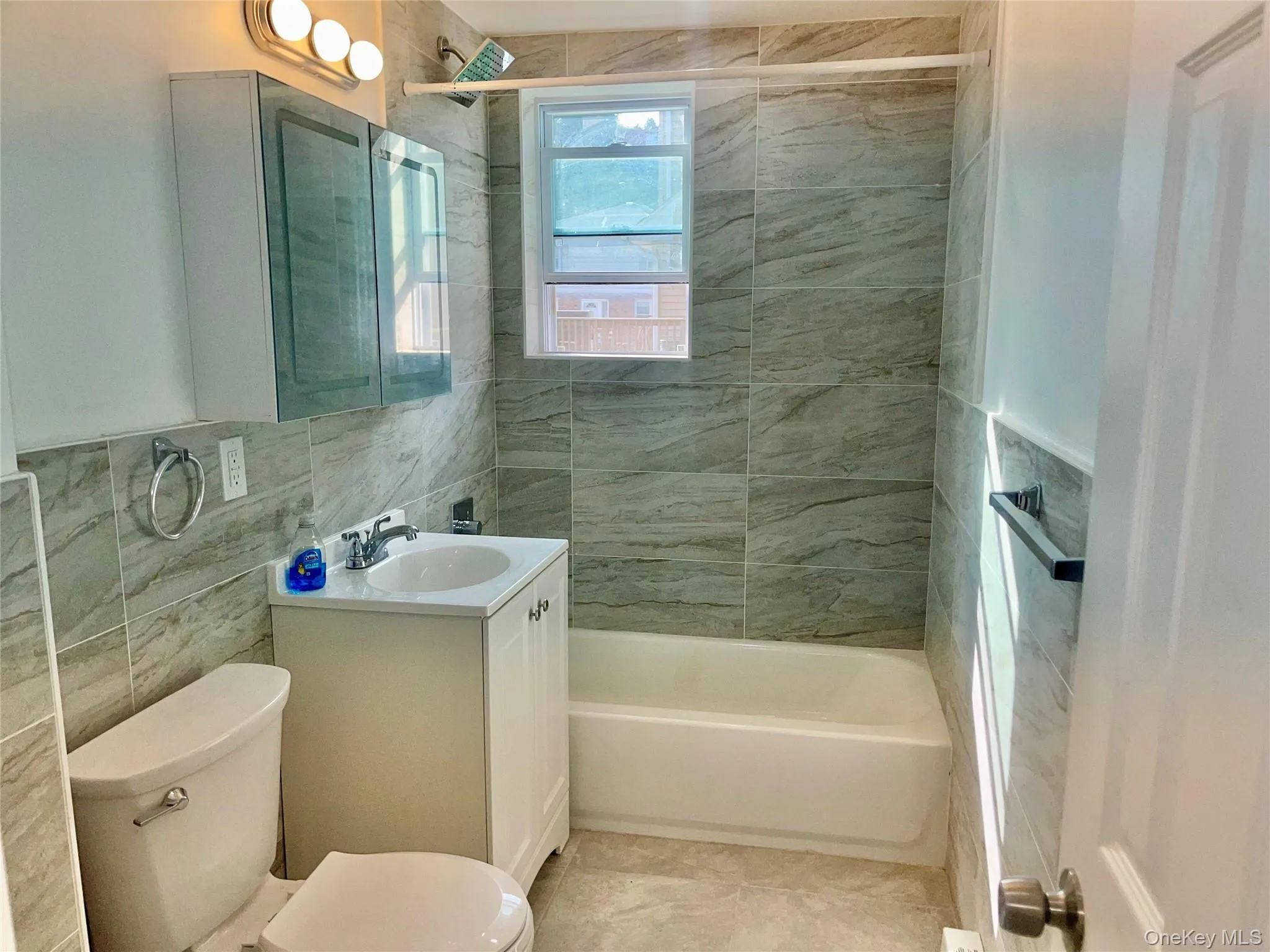 Full bathroom featuring tile walls, vanity, and bathtub / shower combination Full bathroom featuring tile walls, vanity, and bathtub / shower combination