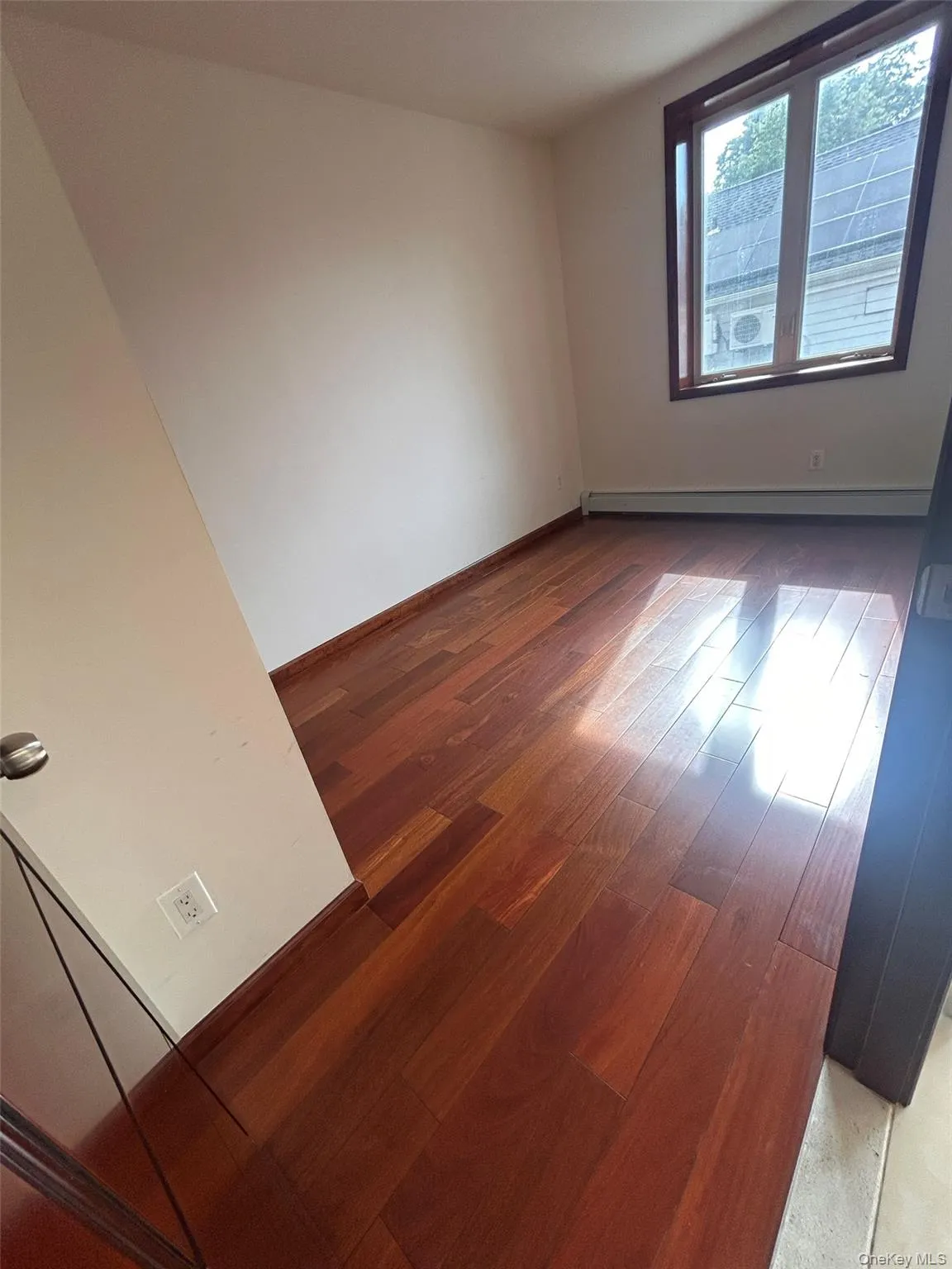 Empty room featuring light wood-type flooring and baseboard heating Empty room featuring light wood-type flooring and baseboard heating