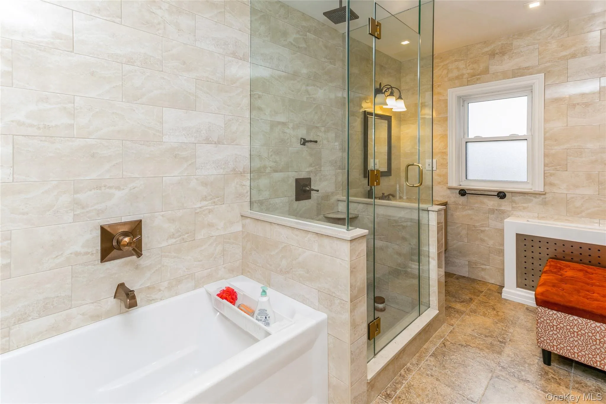 Bathroom featuring tile walls, a shower stall, and a garden tub Bathroom featuring tile walls, a shower stall, and a garden tub