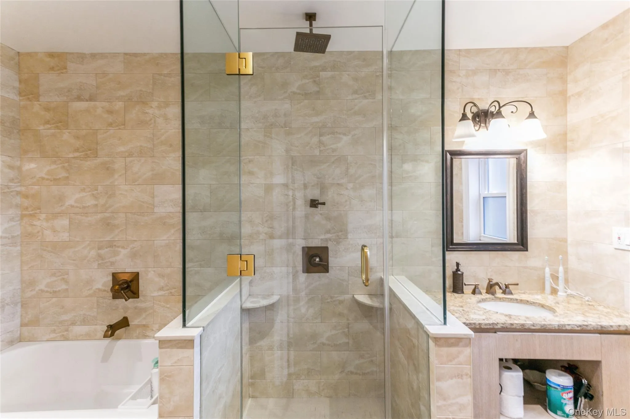 Bathroom with a stall shower, tile walls, a garden tub, and vanity Bathroom with a stall shower, tile walls, a garden tub, and vanity