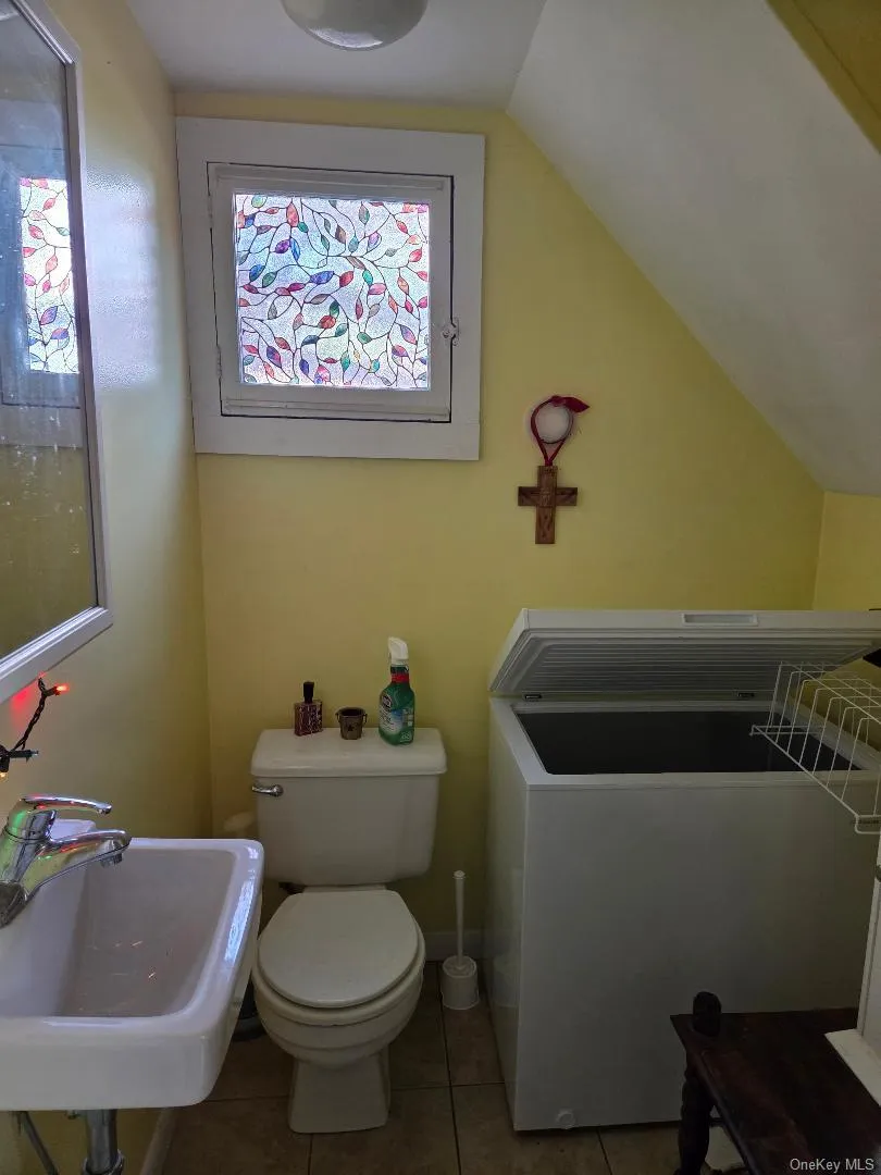 Bathroom with light tile patterned floors and vaulted ceiling Bathroom with light tile patterned floors and vaulted ceiling