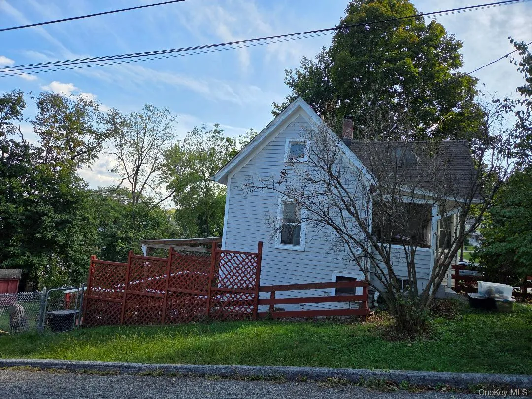 View of side of property featuring a chimney and a wooden deck View of side of property featuring a chimney and a wooden deck