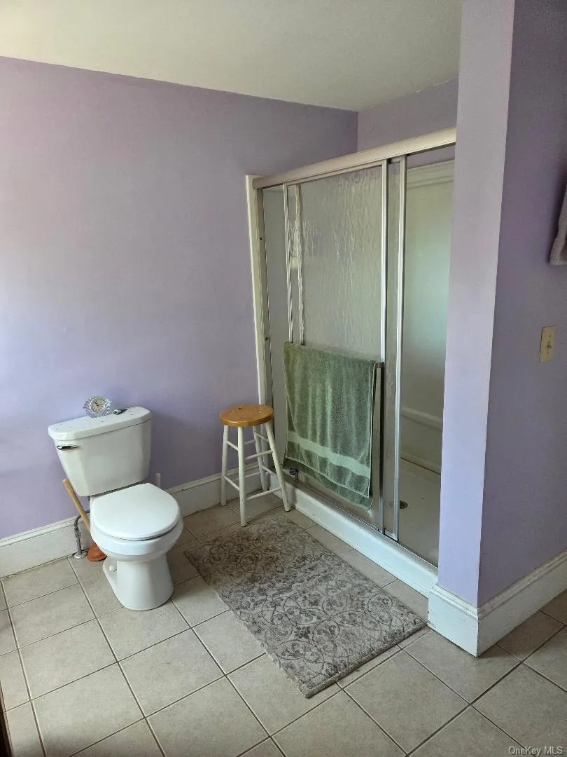 Full bath with a stall shower and light tile patterned floors Full bath with a stall shower and light tile patterned floors