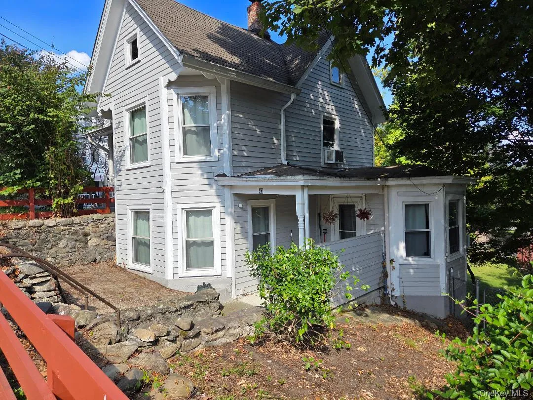 View of front of house with a porch with access to the lower living area. View of front of house with a porch with access to the lower living area.