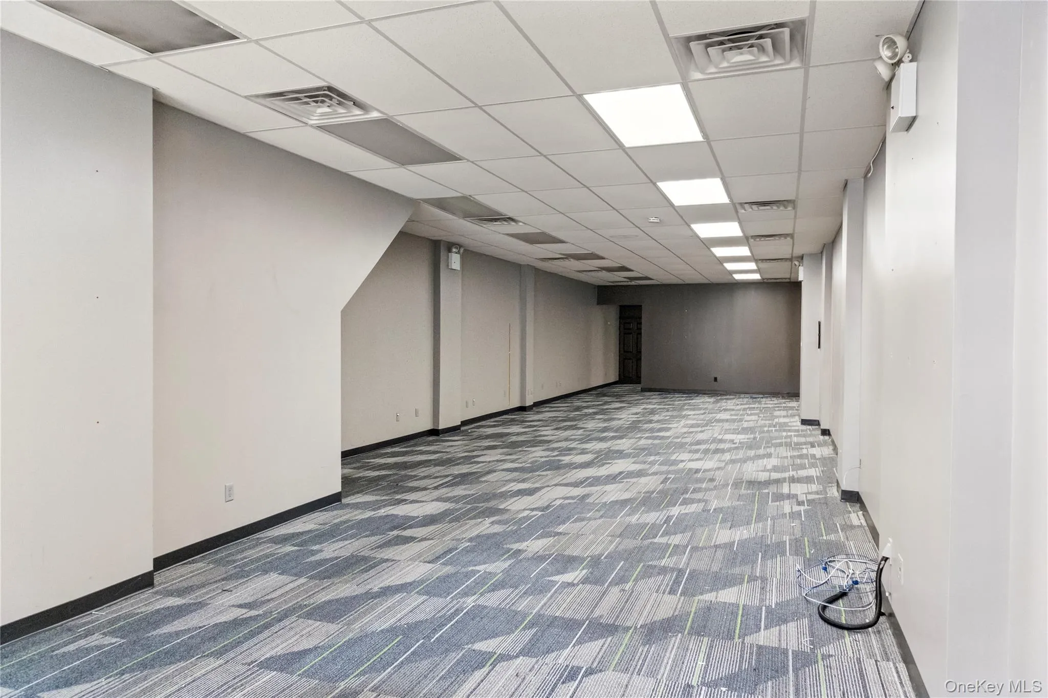 Finished basement with carpet and a drop ceiling Finished basement with carpet and a drop ceiling