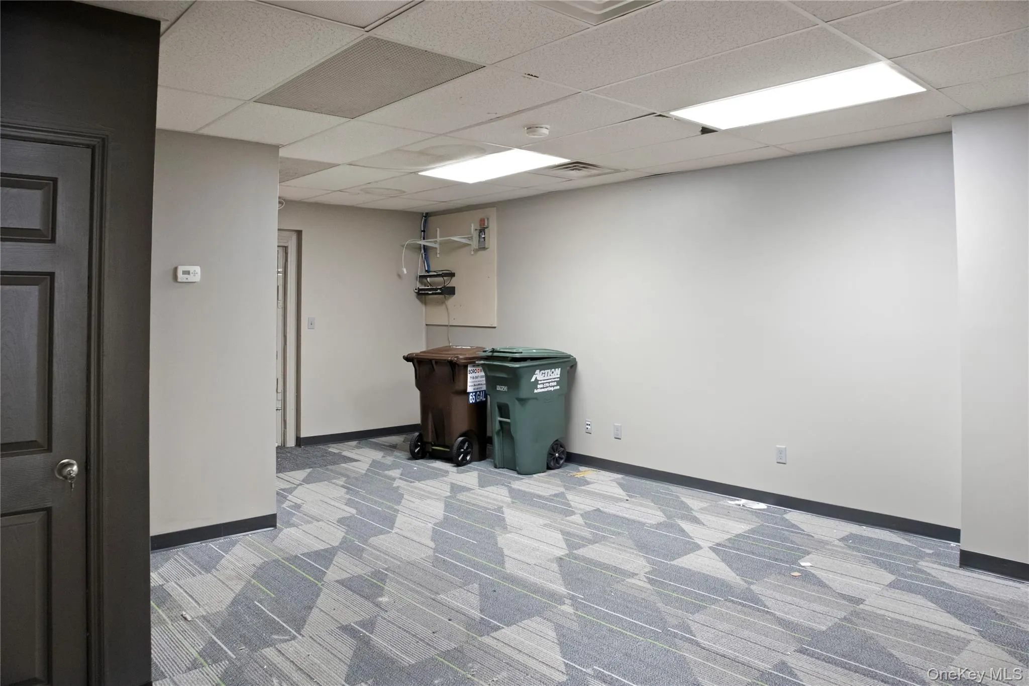 Basement with light carpet and a paneled ceiling Basement with light carpet and a paneled ceiling