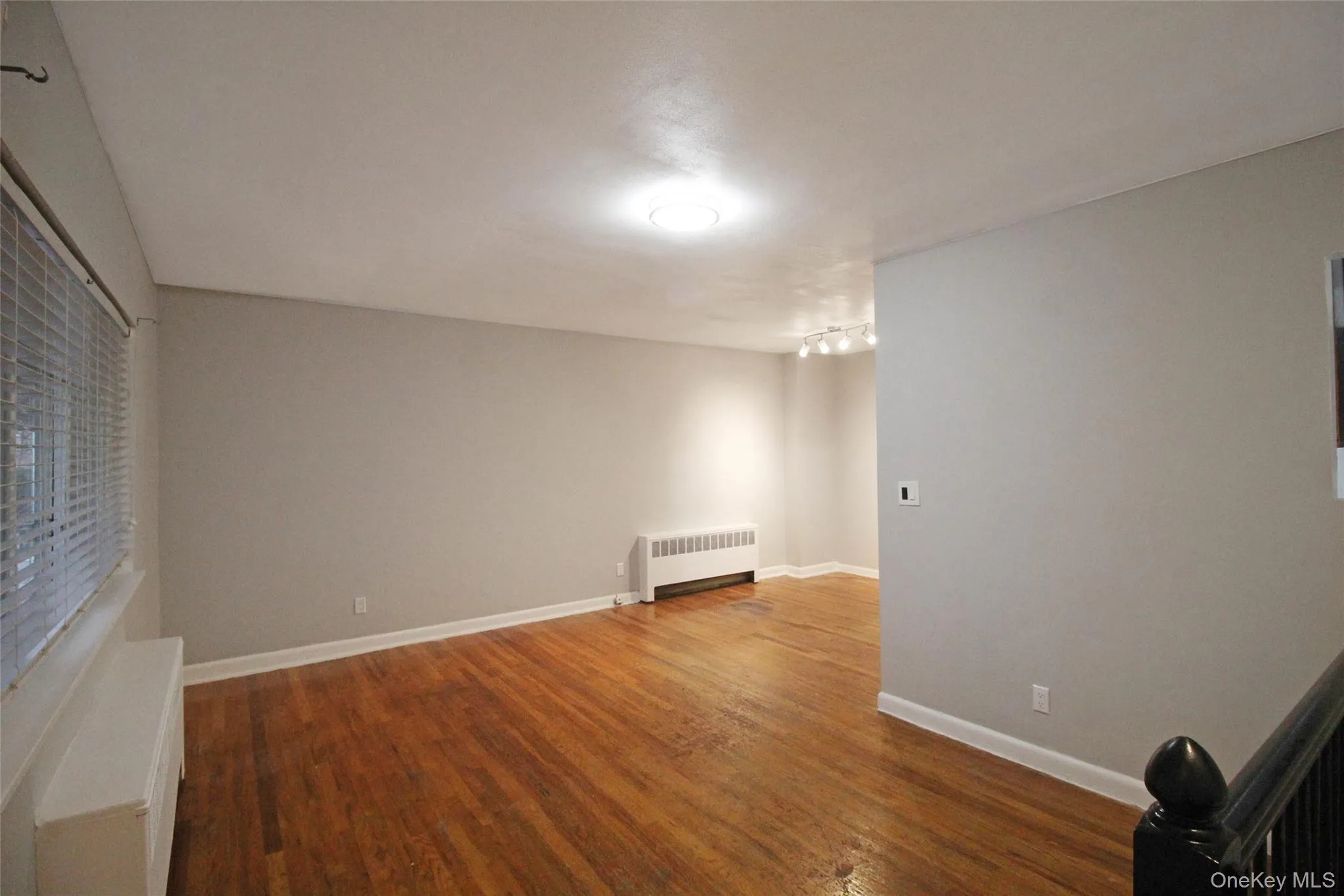 Unfurnished room featuring dark wood-type flooring and radiator heating unit Unfurnished room featuring dark wood-type flooring and radiator heating unit
