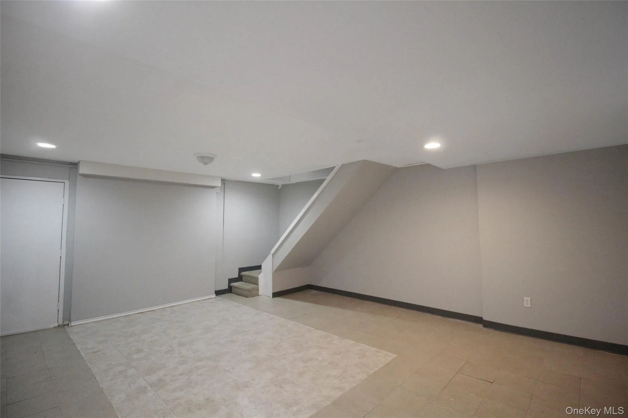 Finished below grade area with stairs and recessed lighting Finished below grade area with stairs and recessed lighting